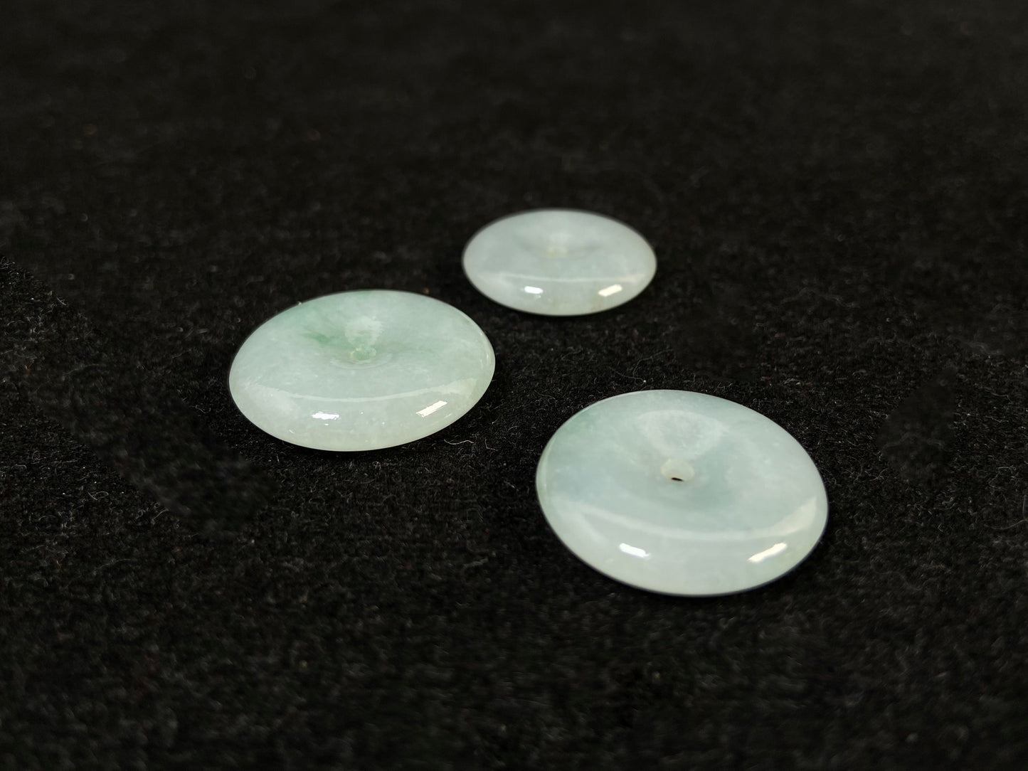 Translucent white jade cabochons featuring soft green patterns.