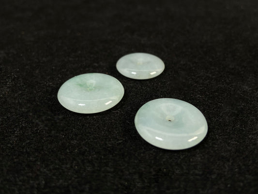 Translucent white jade cabochons featuring soft green patterns.