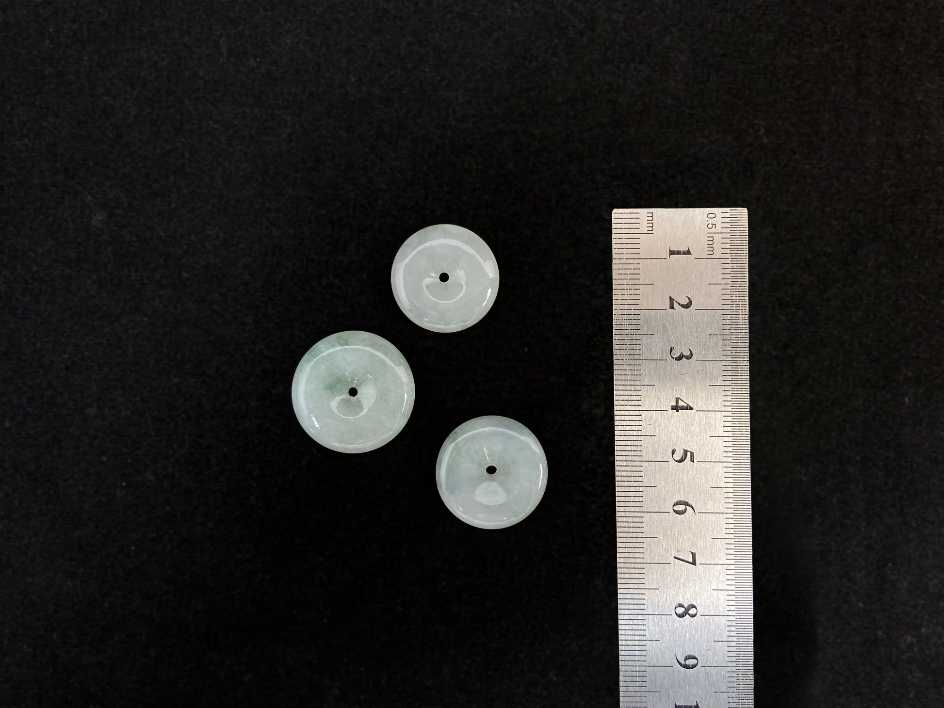 Translucent white jade cabochons featuring soft green patterns.
