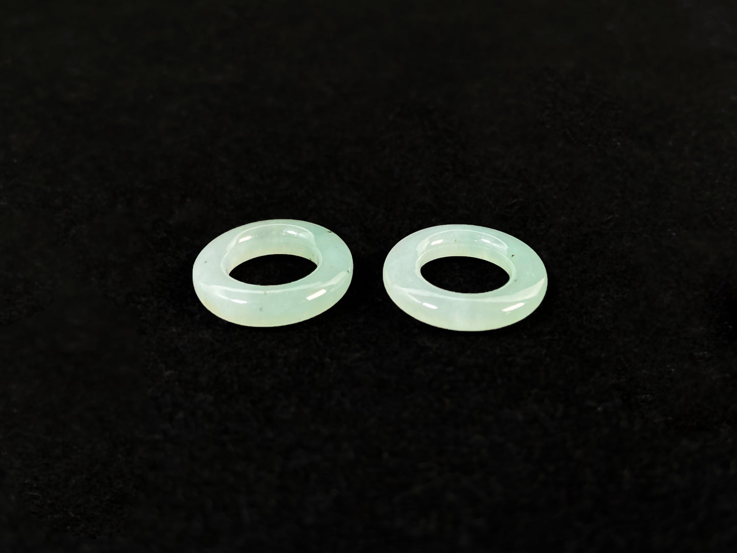 A clear light green jade hoop with black accents.