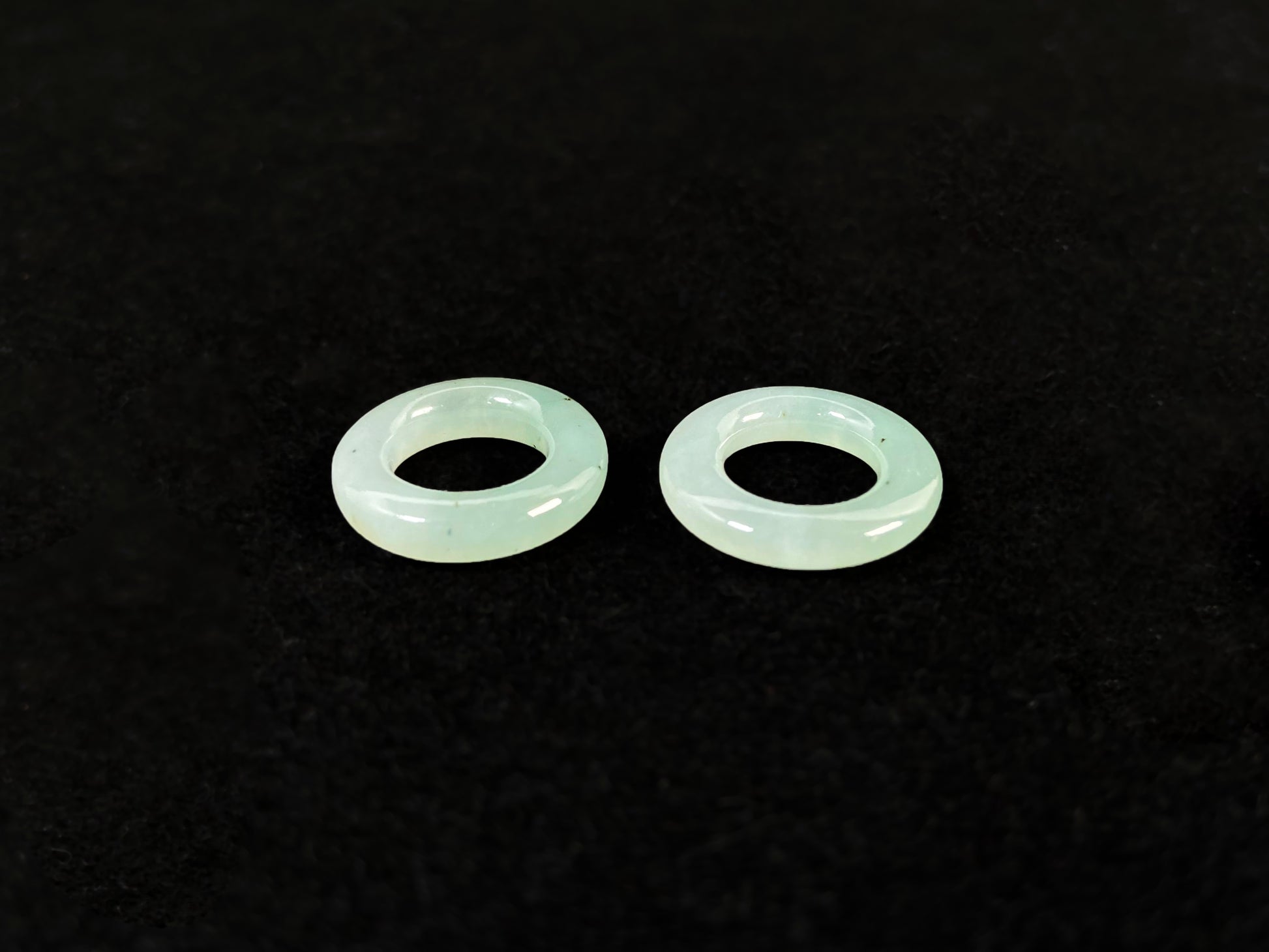 A clear light green jade hoop with black accents.
