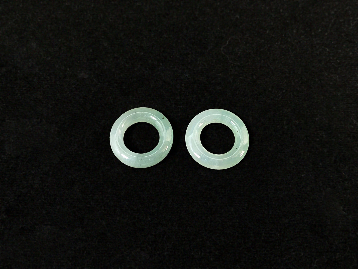 A clear light green jade hoop with black accents.