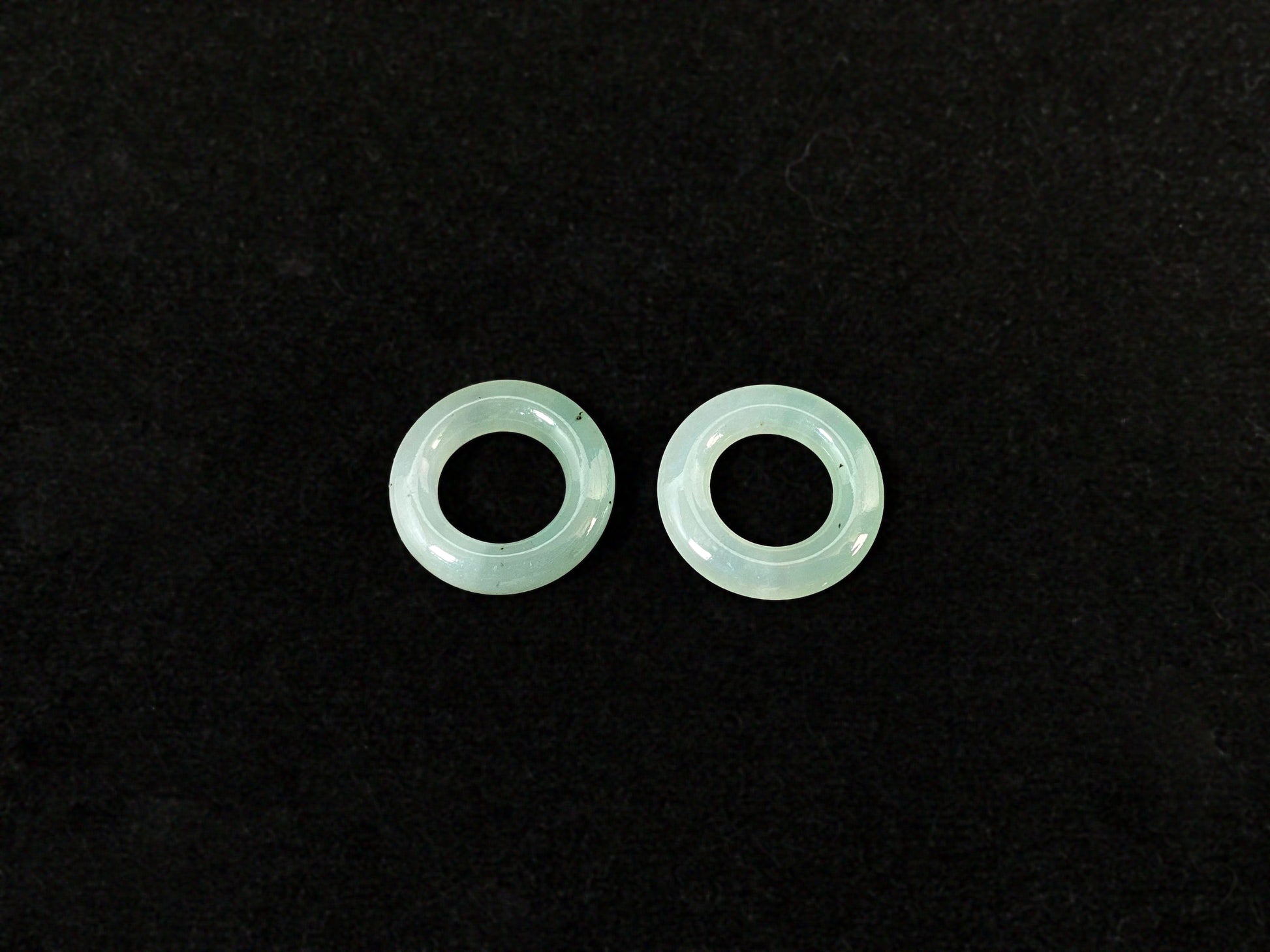 A clear light green jade hoop with black accents.