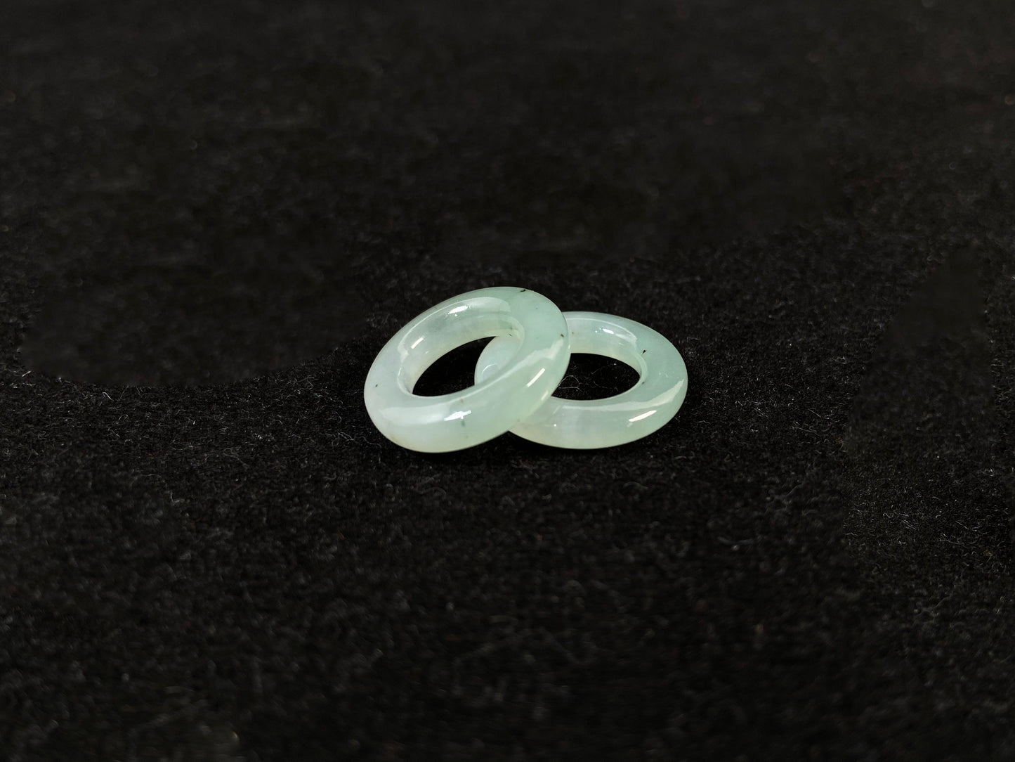 A clear light green jade hoop with black accents.