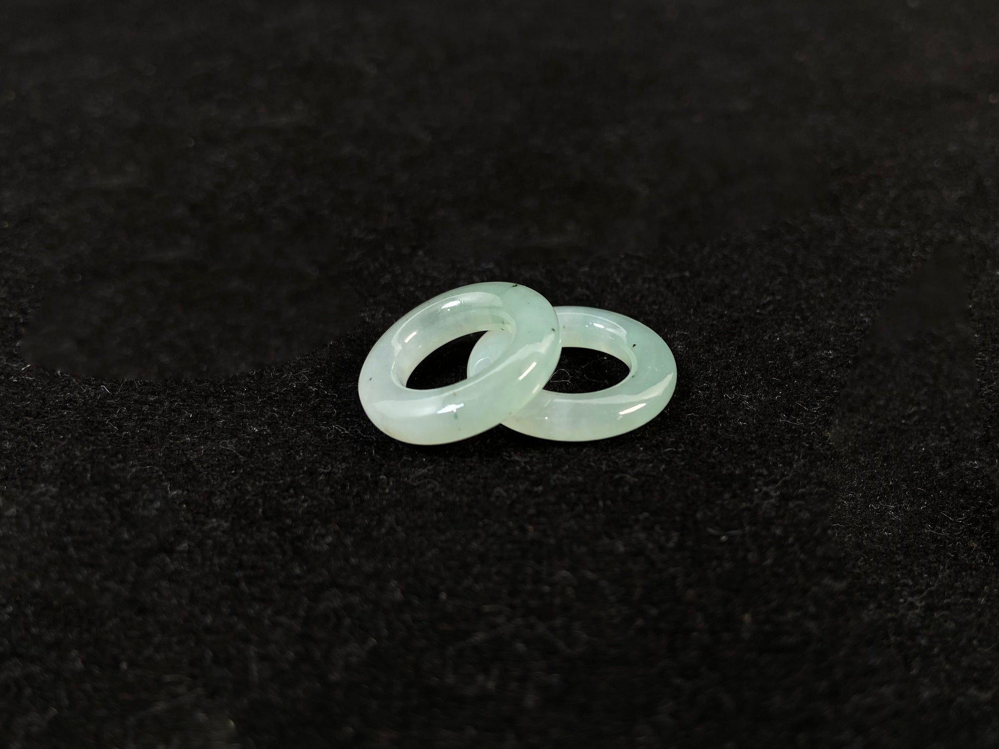 A clear light green jade hoop with black accents.