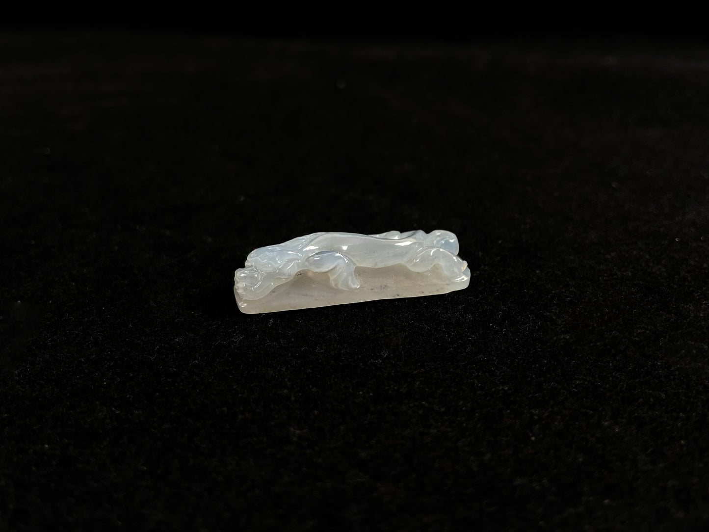 This jadeite is carved into a dragon motif in semi-transparent, milky white jade.