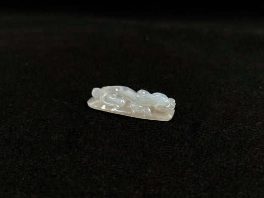 This jadeite is carved into a dragon motif in semi-transparent, milky white jade.