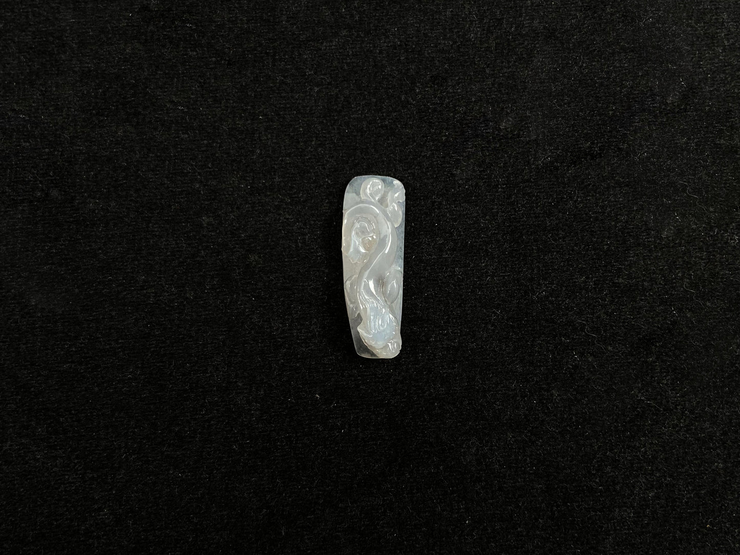 This jadeite is carved into a dragon motif in semi-transparent, milky white jade.