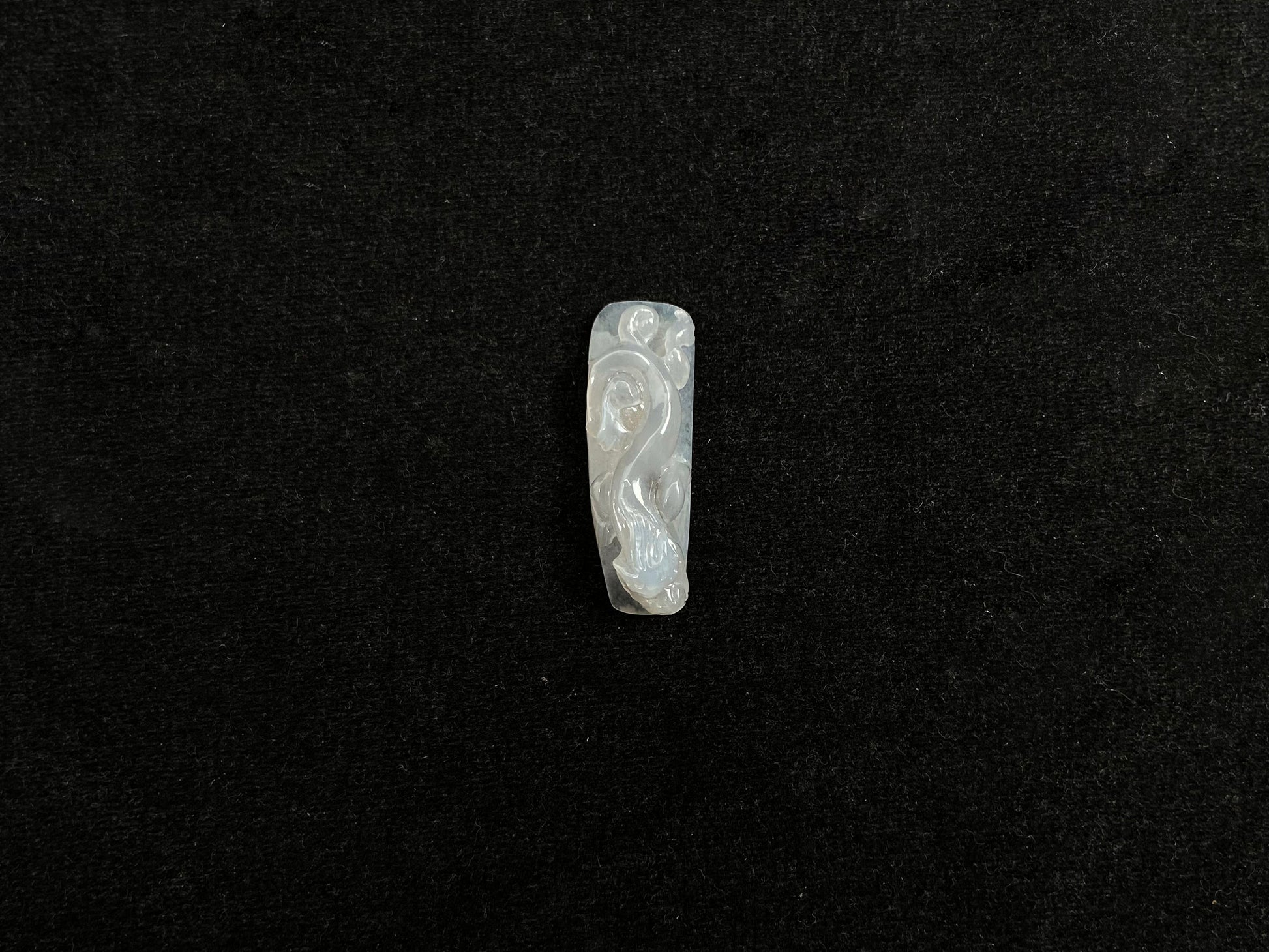 This jadeite is carved into a dragon motif in semi-transparent, milky white jade.