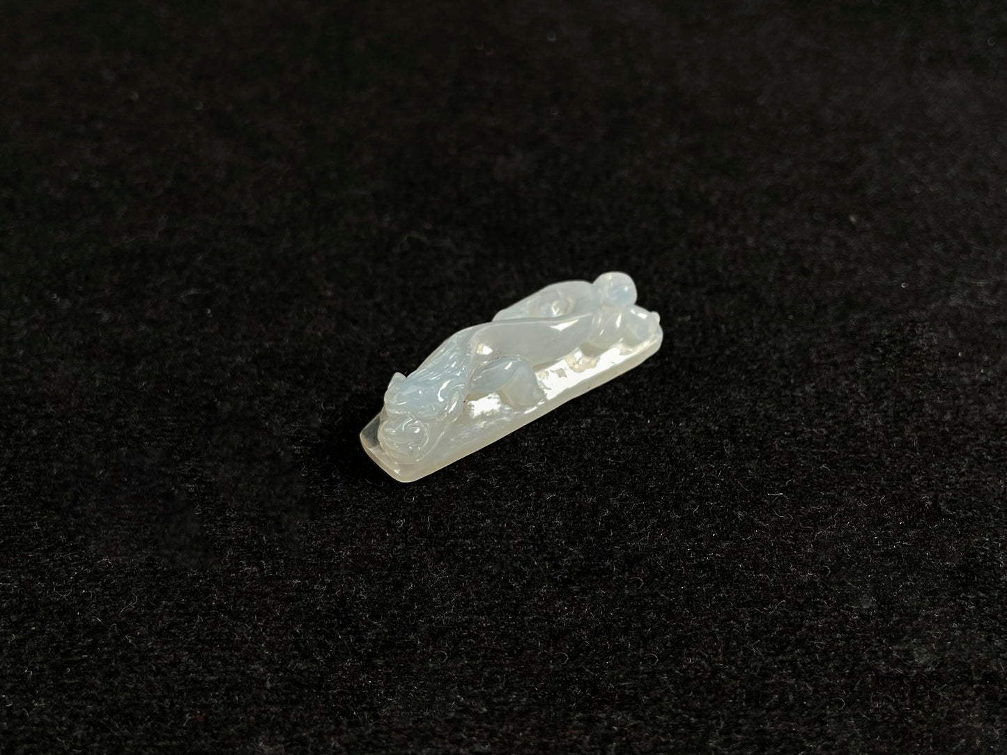 This jadeite is carved into a dragon motif in semi-transparent, milky white jade.