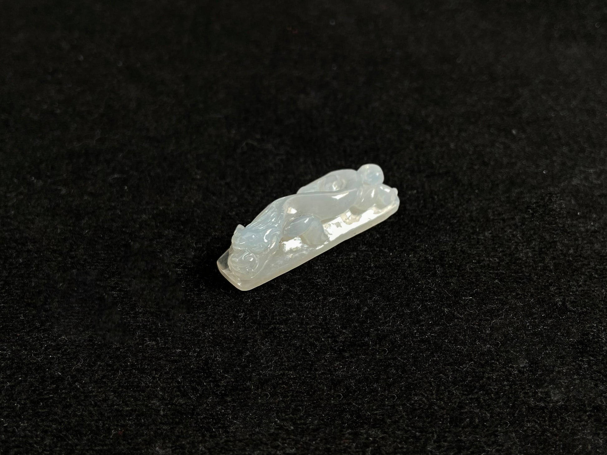 This jadeite is carved into a dragon motif in semi-transparent, milky white jade.