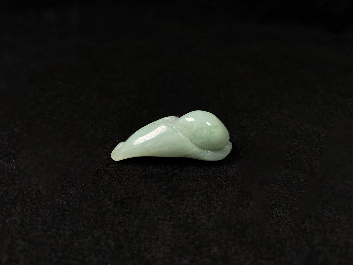 A light green jadeite magnolia bud carving.