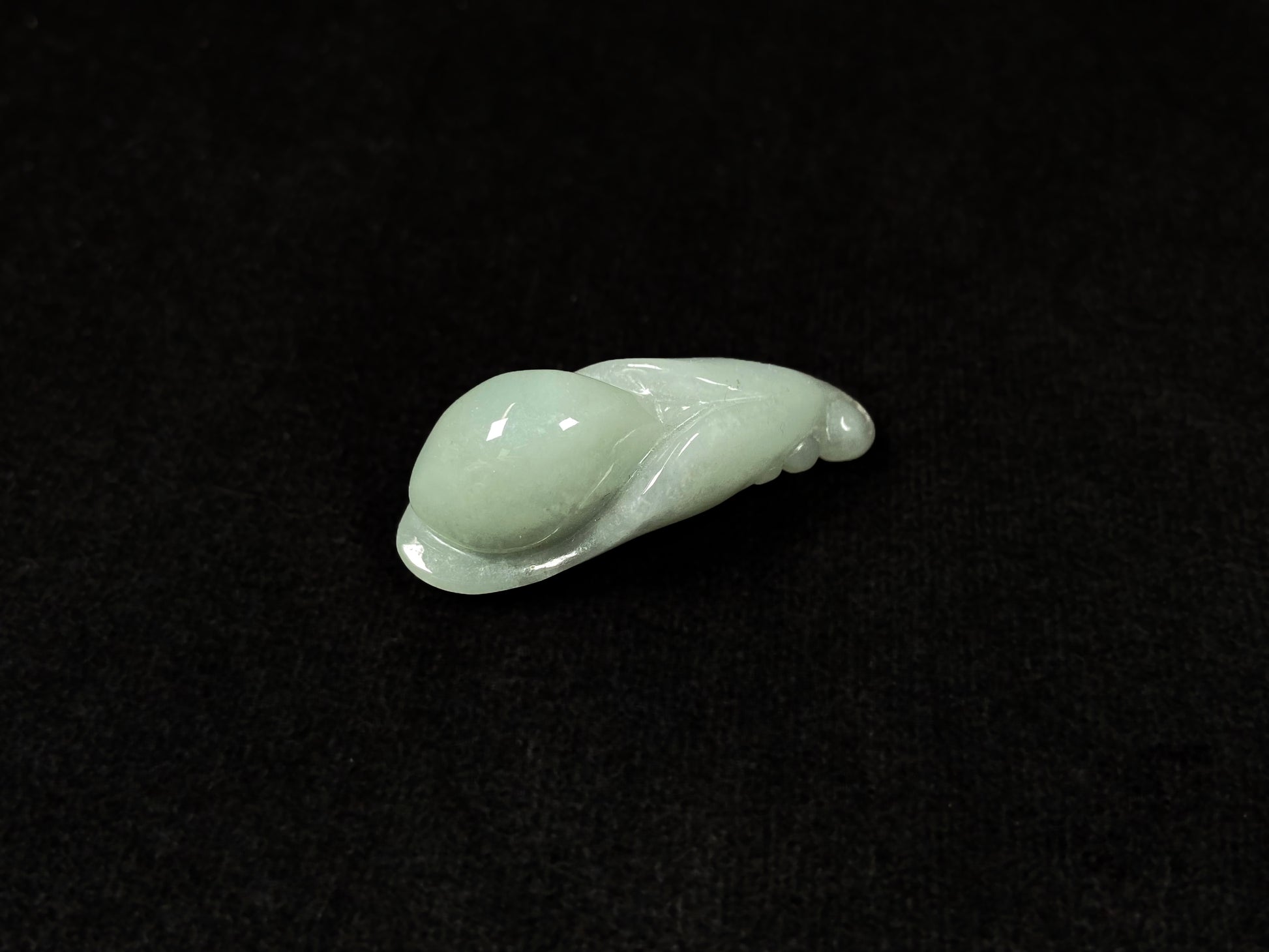 A light green jadeite magnolia bud carving.