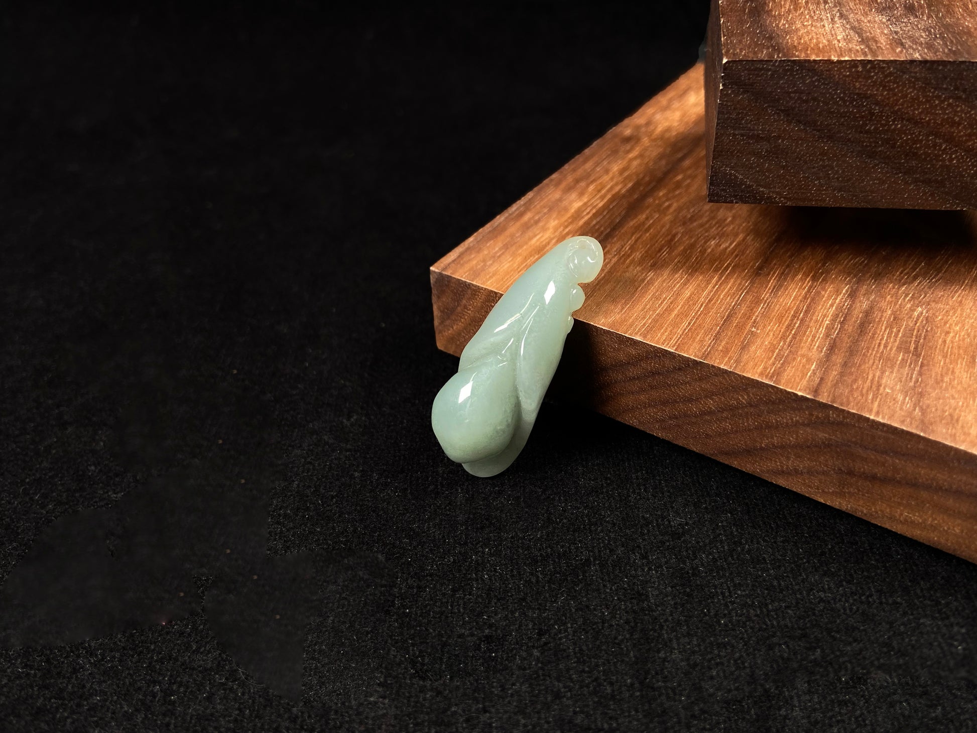 A light green jadeite magnolia bud carving.