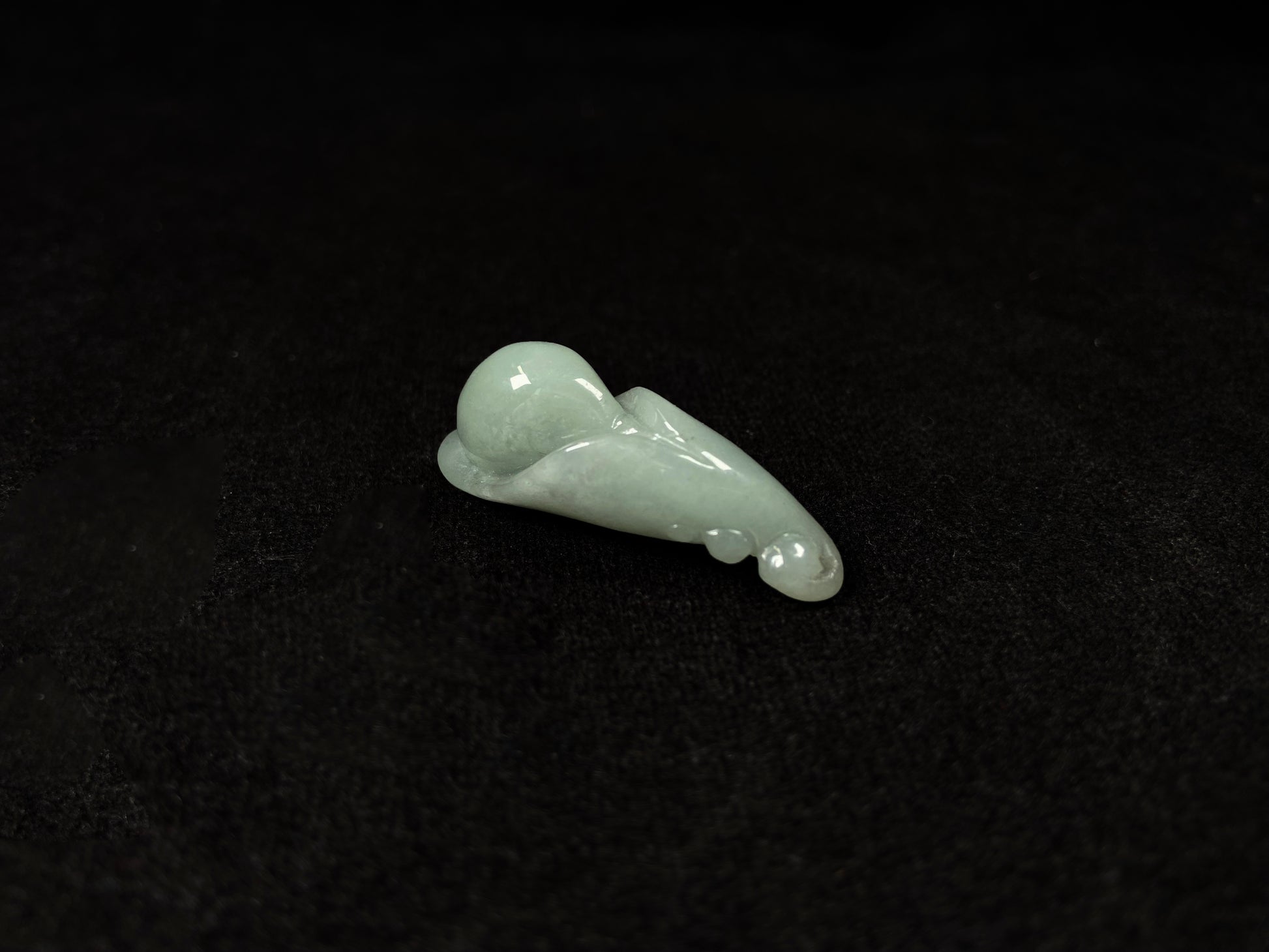 A light green jadeite magnolia bud carving.