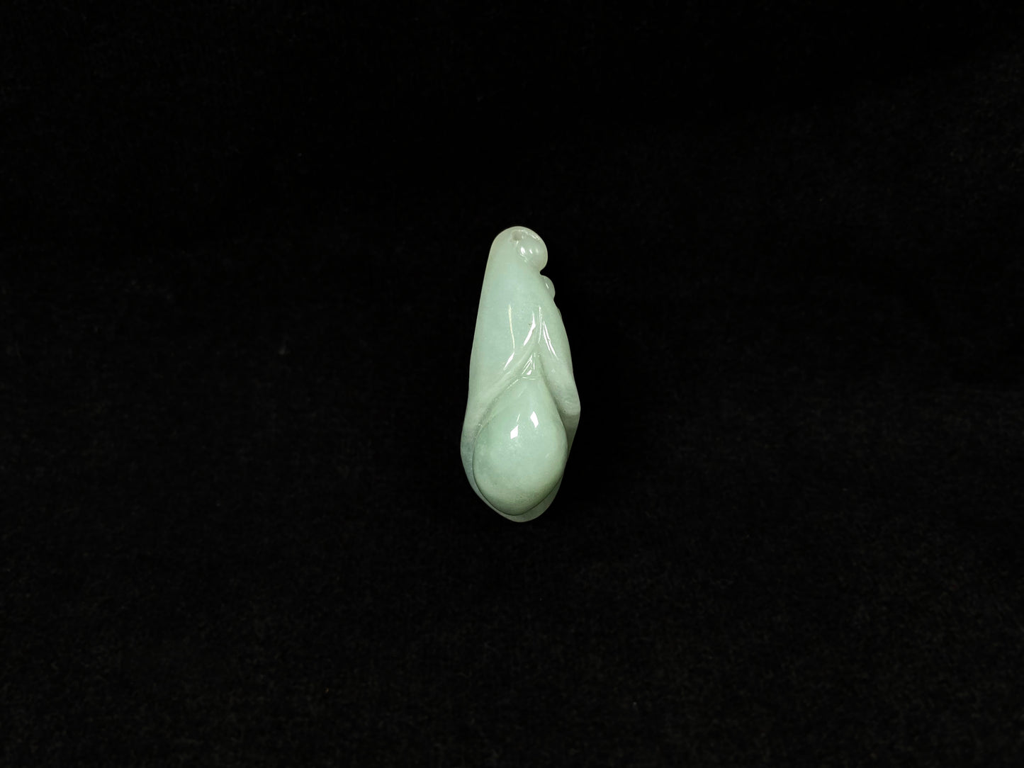 A light green jadeite magnolia bud carving.