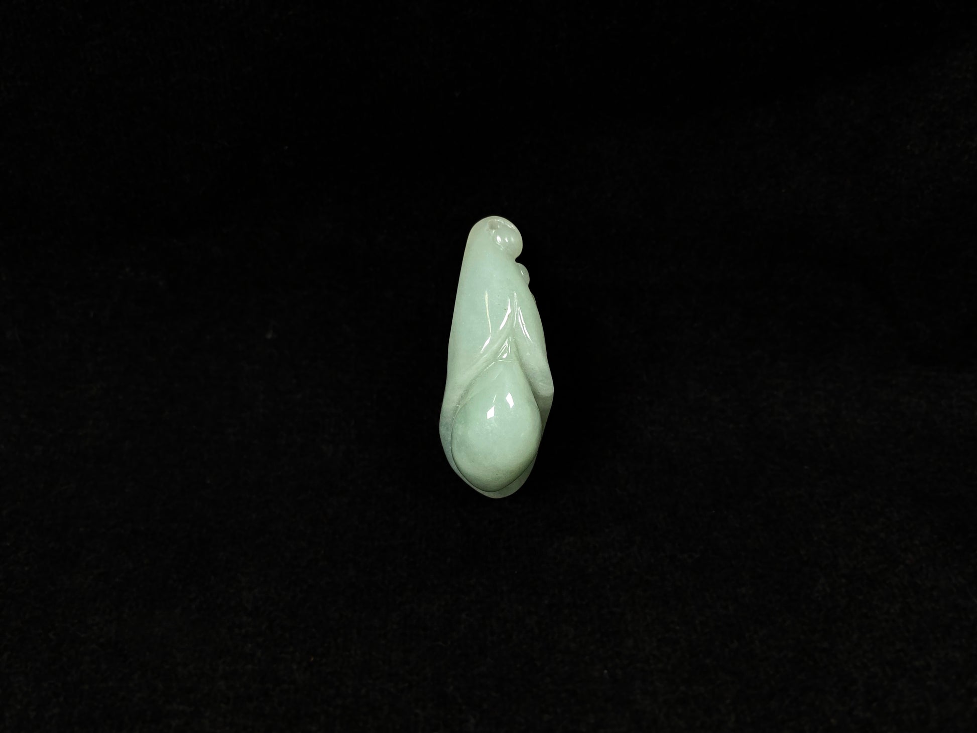 A light green jadeite magnolia bud carving.