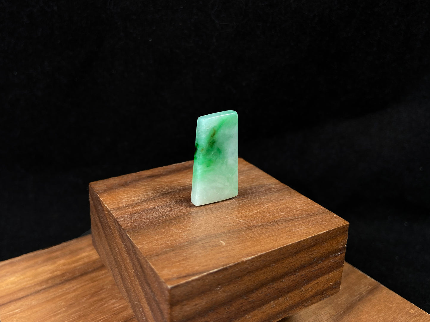 The jadeite wushi plaque presents a clean white base adorned with natural green veining.