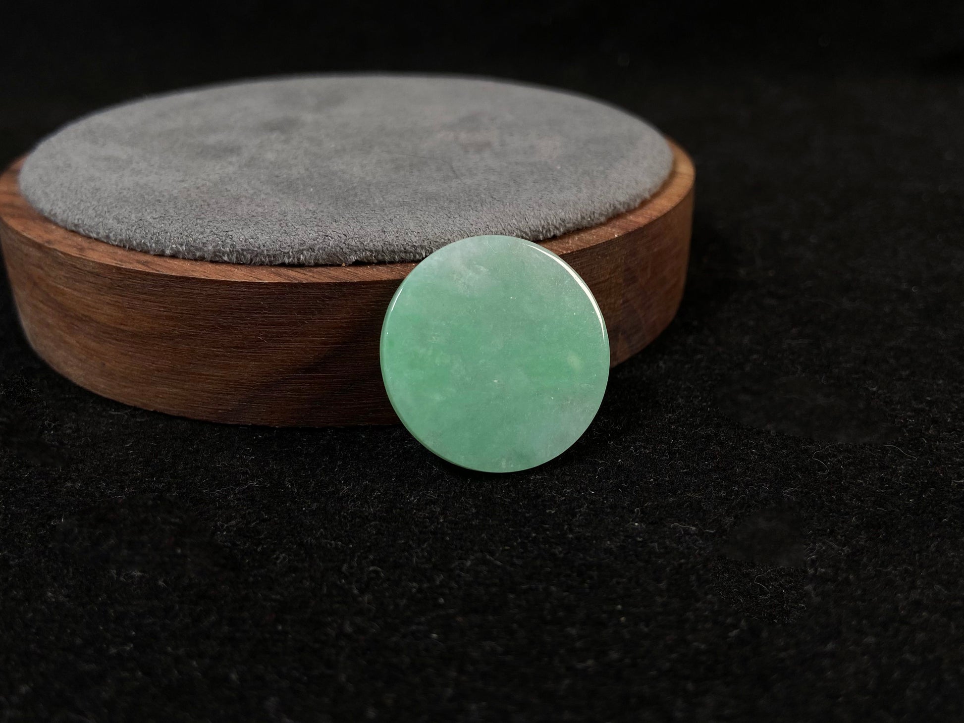 A delicate green jade stone with circular proportions.
