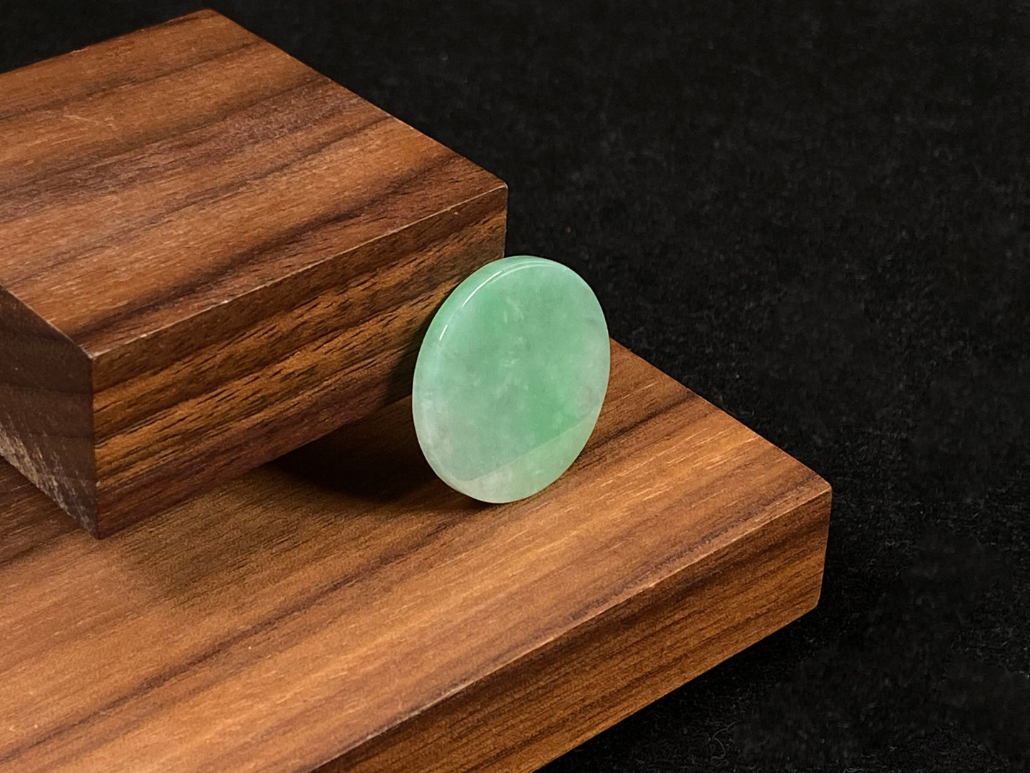 A delicate green jade stone with circular proportions.