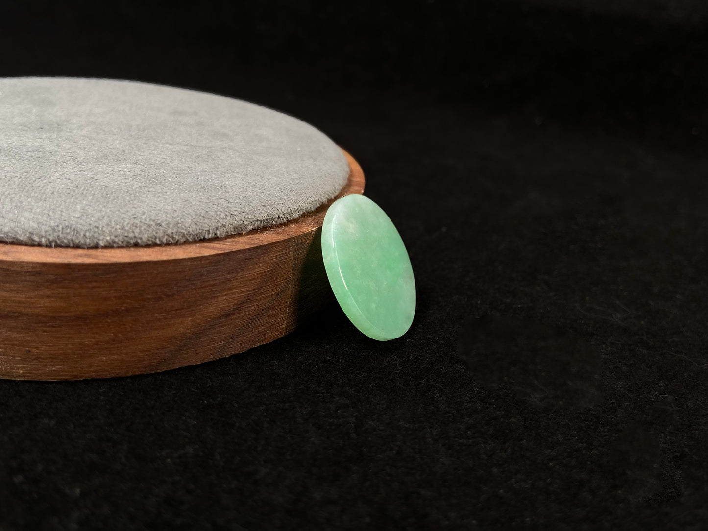 A delicate green jade stone with circular proportions.