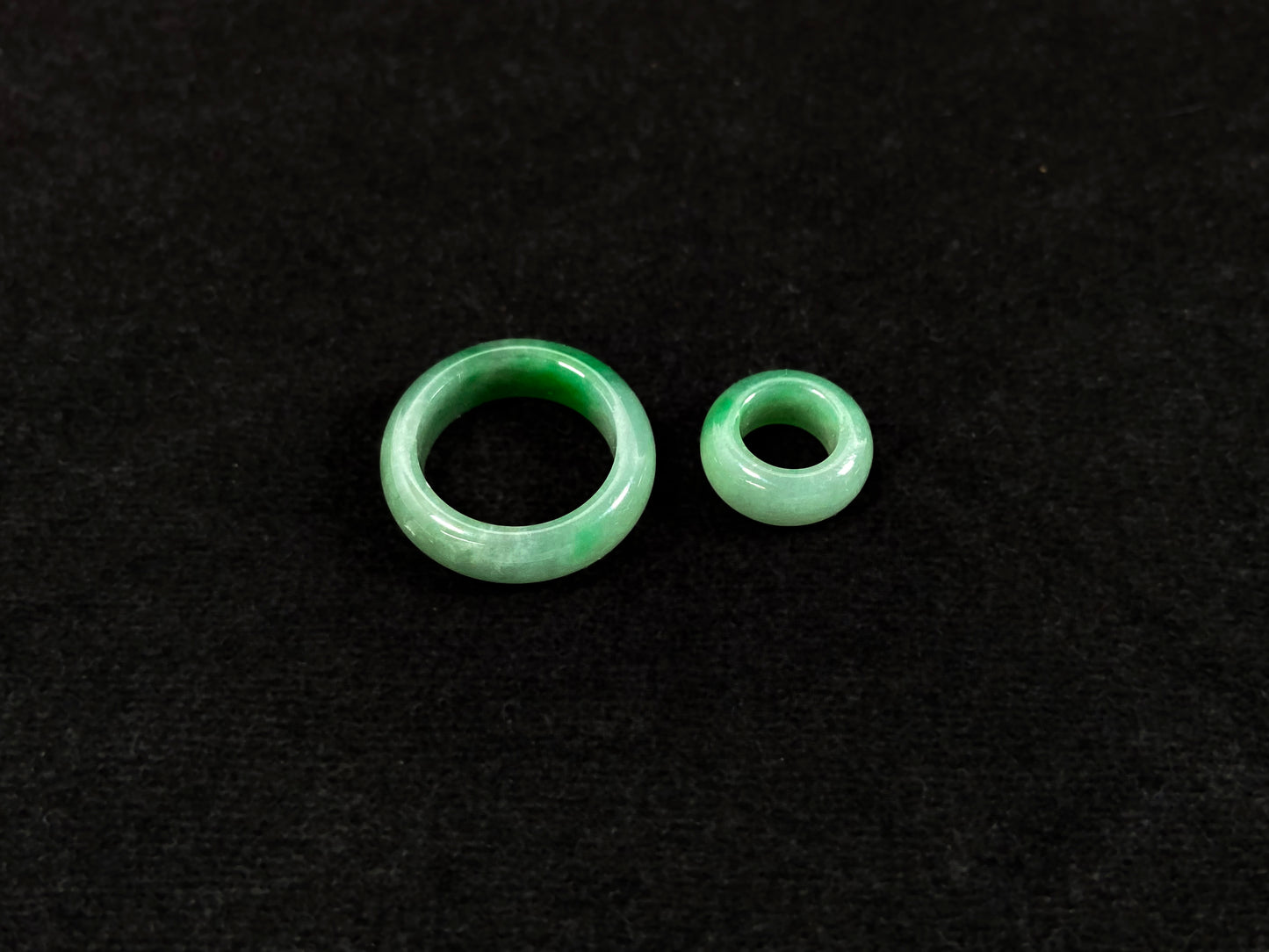 A loose jadeite with a light green base and vibrant green mother-child pendant accents.