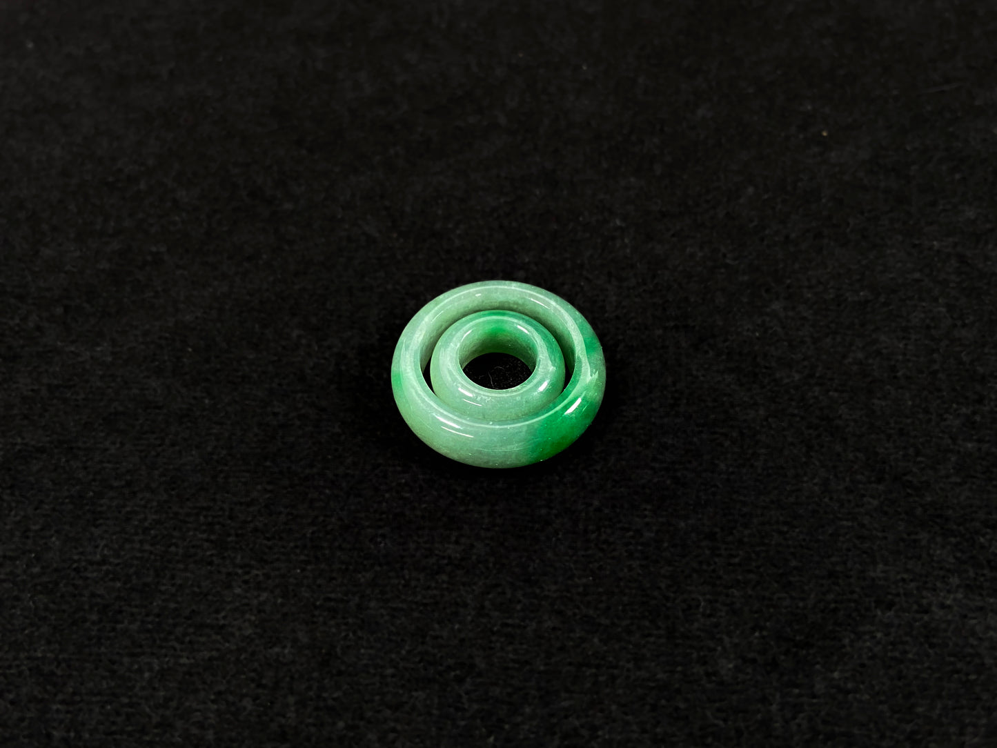 A loose jadeite with a light green base and vibrant green mother-child pendant accents.