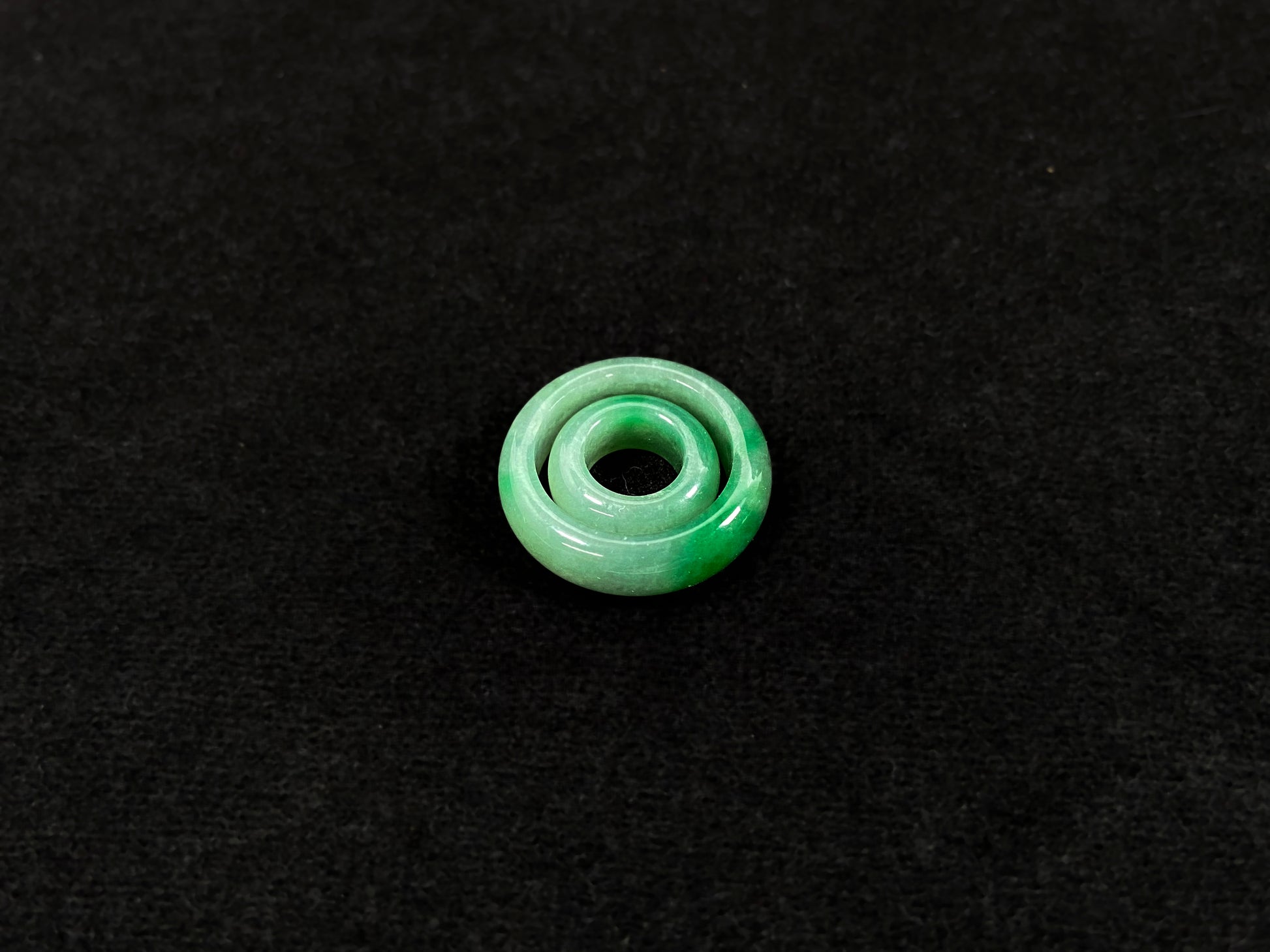 A loose jadeite with a light green base and vibrant green mother-child pendant accents.