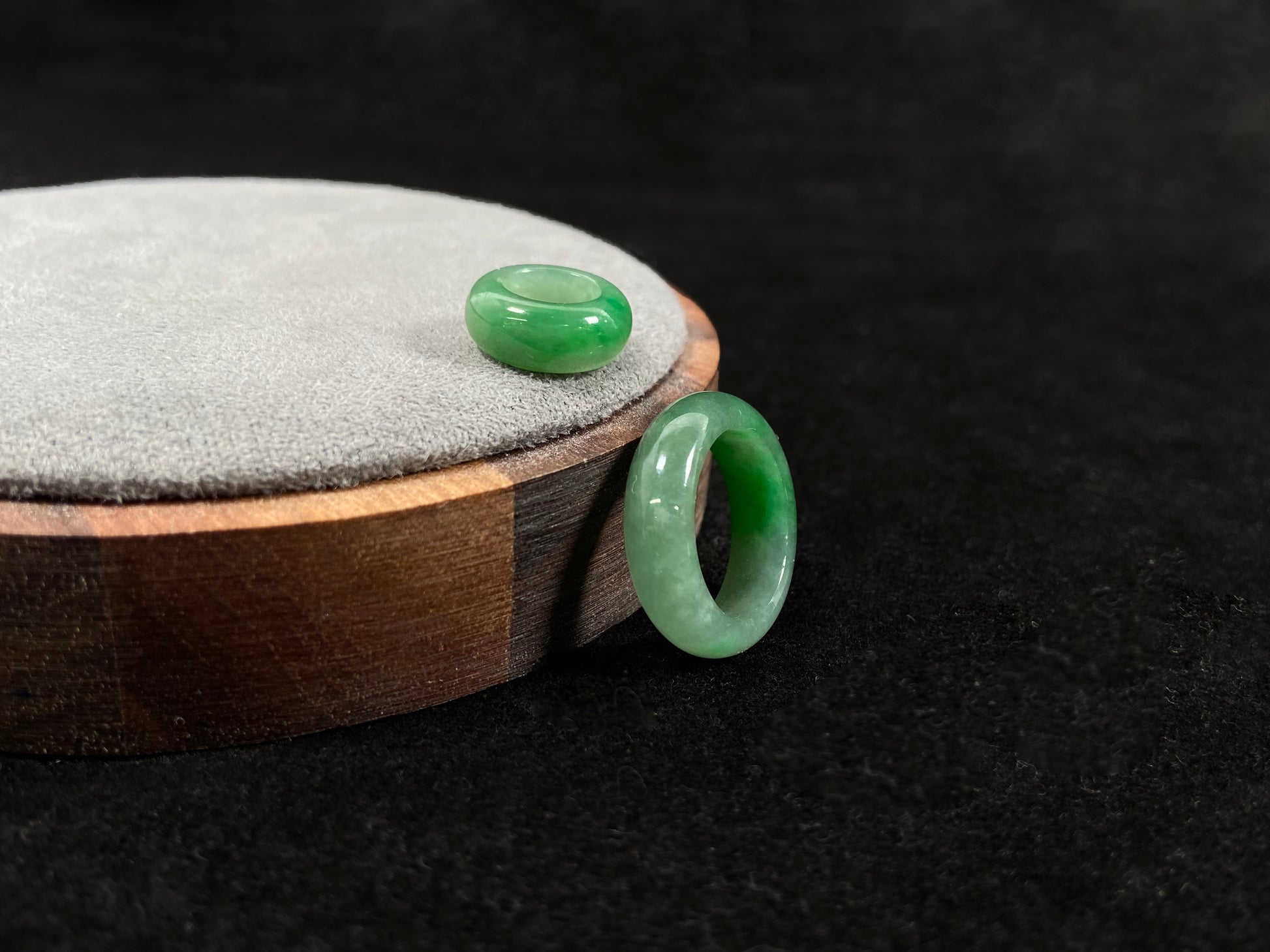 A loose jadeite with a light green base and vibrant green mother-child pendant accents.