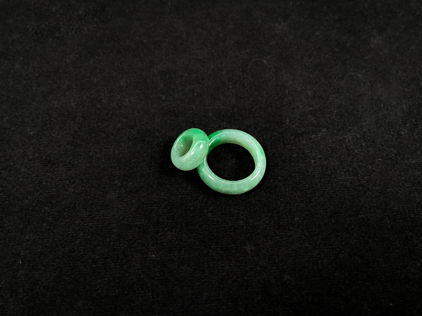 A loose jadeite with a light green base and vibrant green mother-child pendant accents.