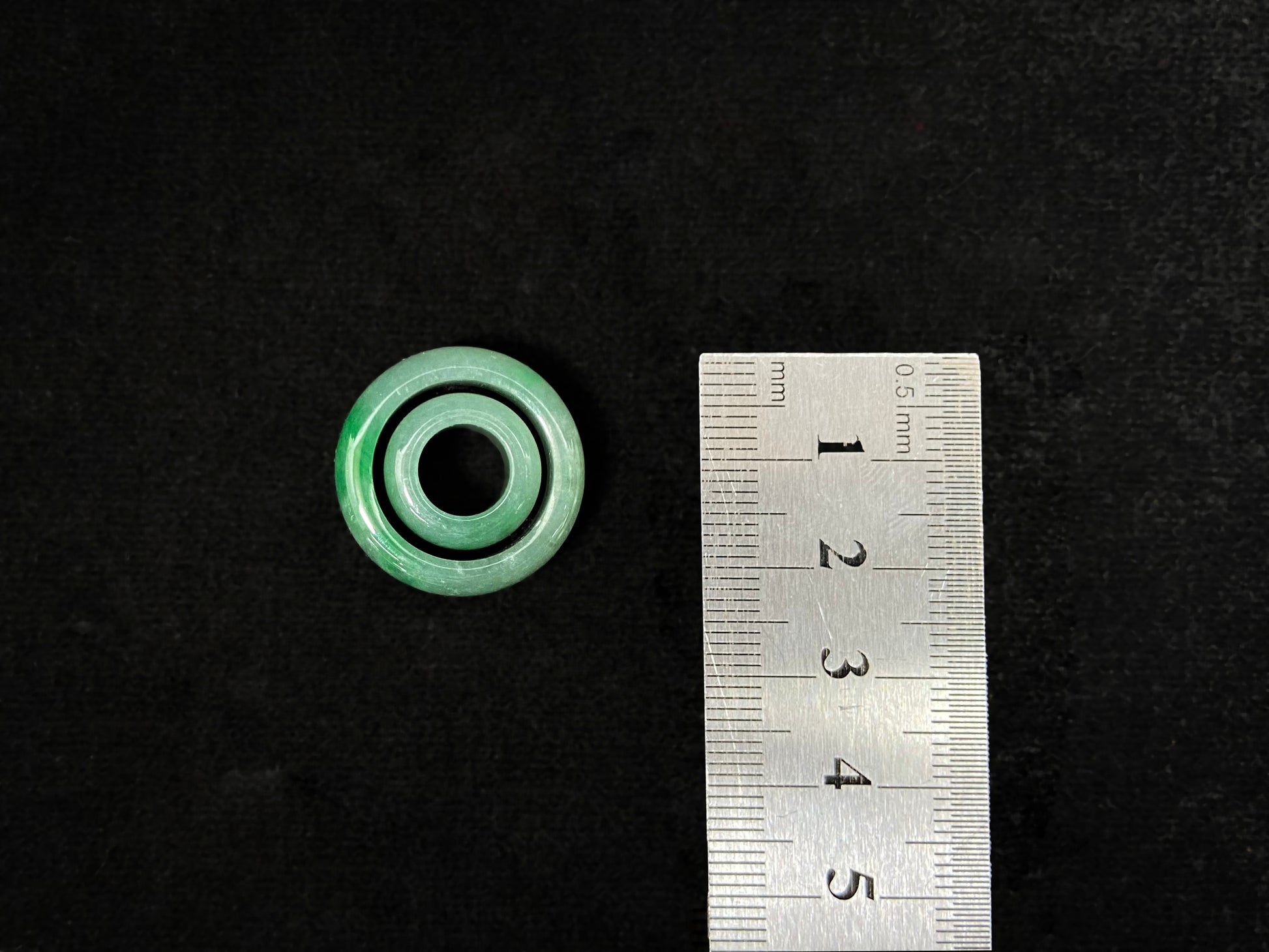 A loose jadeite with a light green base and vibrant green mother-child pendant accents.