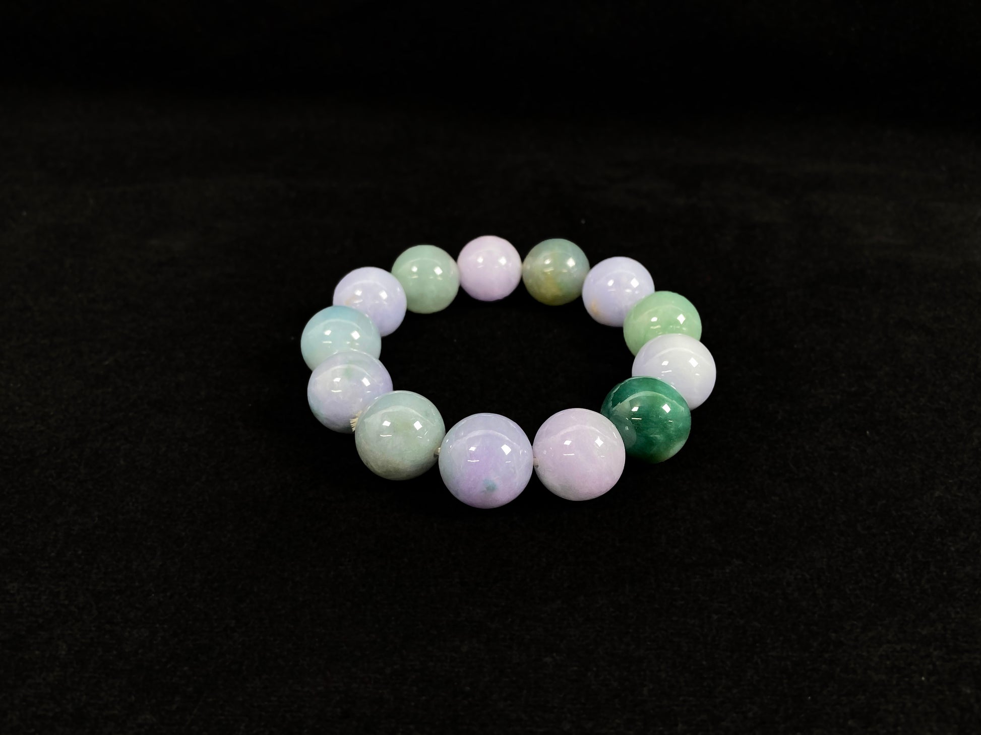 A beaded jadeite bracelet featuring purple, blue, light green, and dark green.