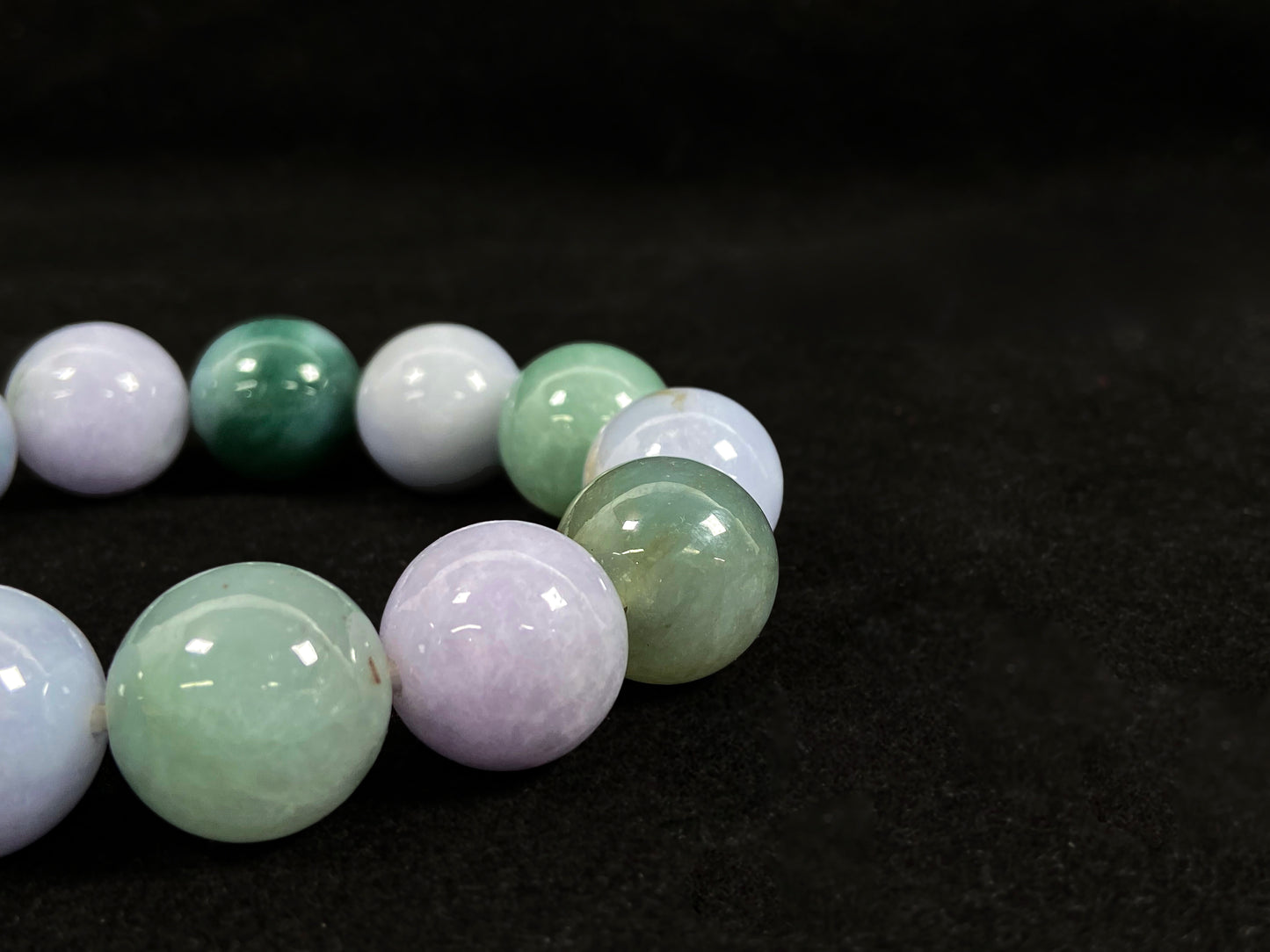 A beaded jadeite bracelet featuring purple, blue, light green, and dark green.
