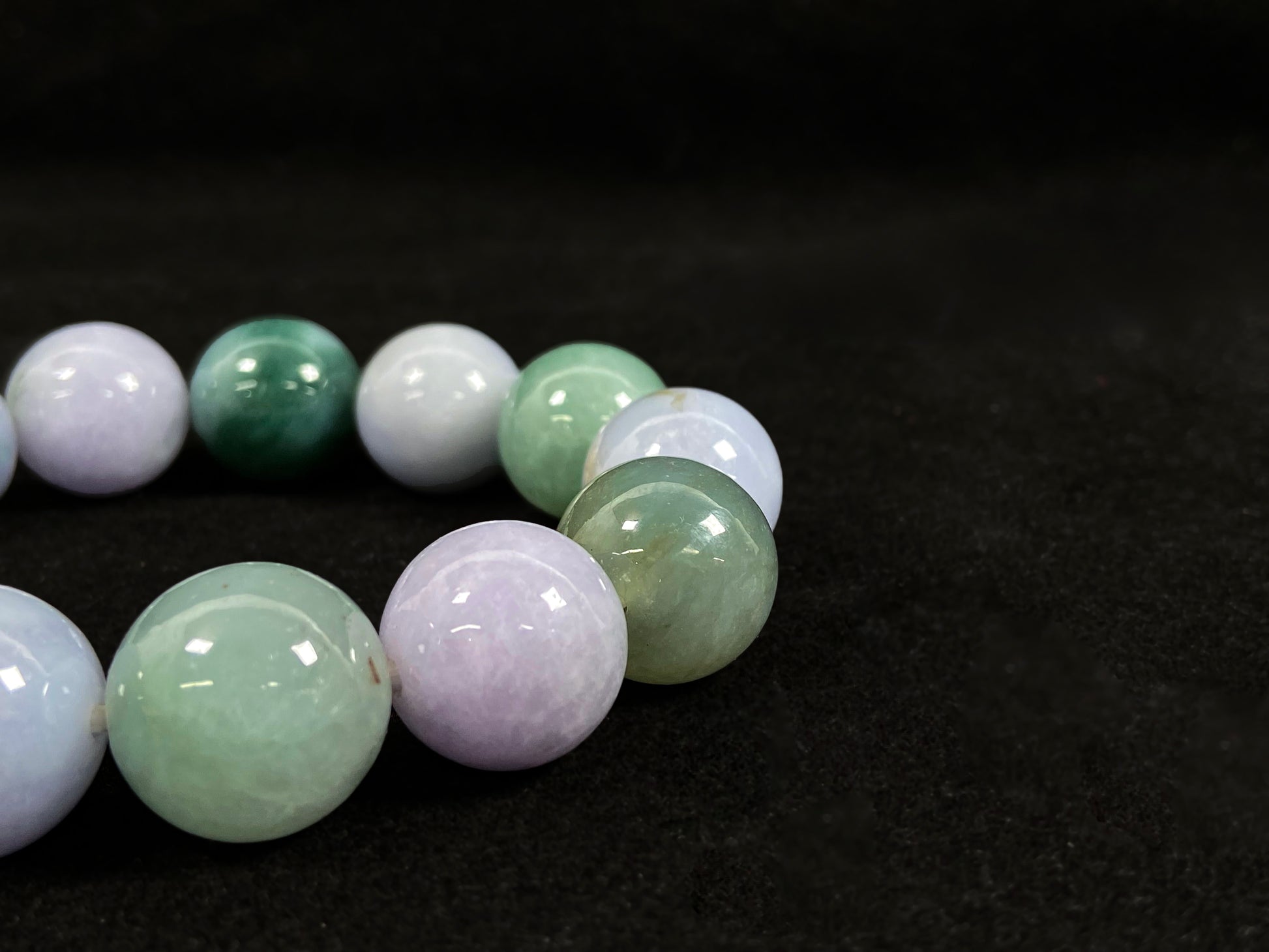 A beaded jadeite bracelet featuring purple, blue, light green, and dark green.
