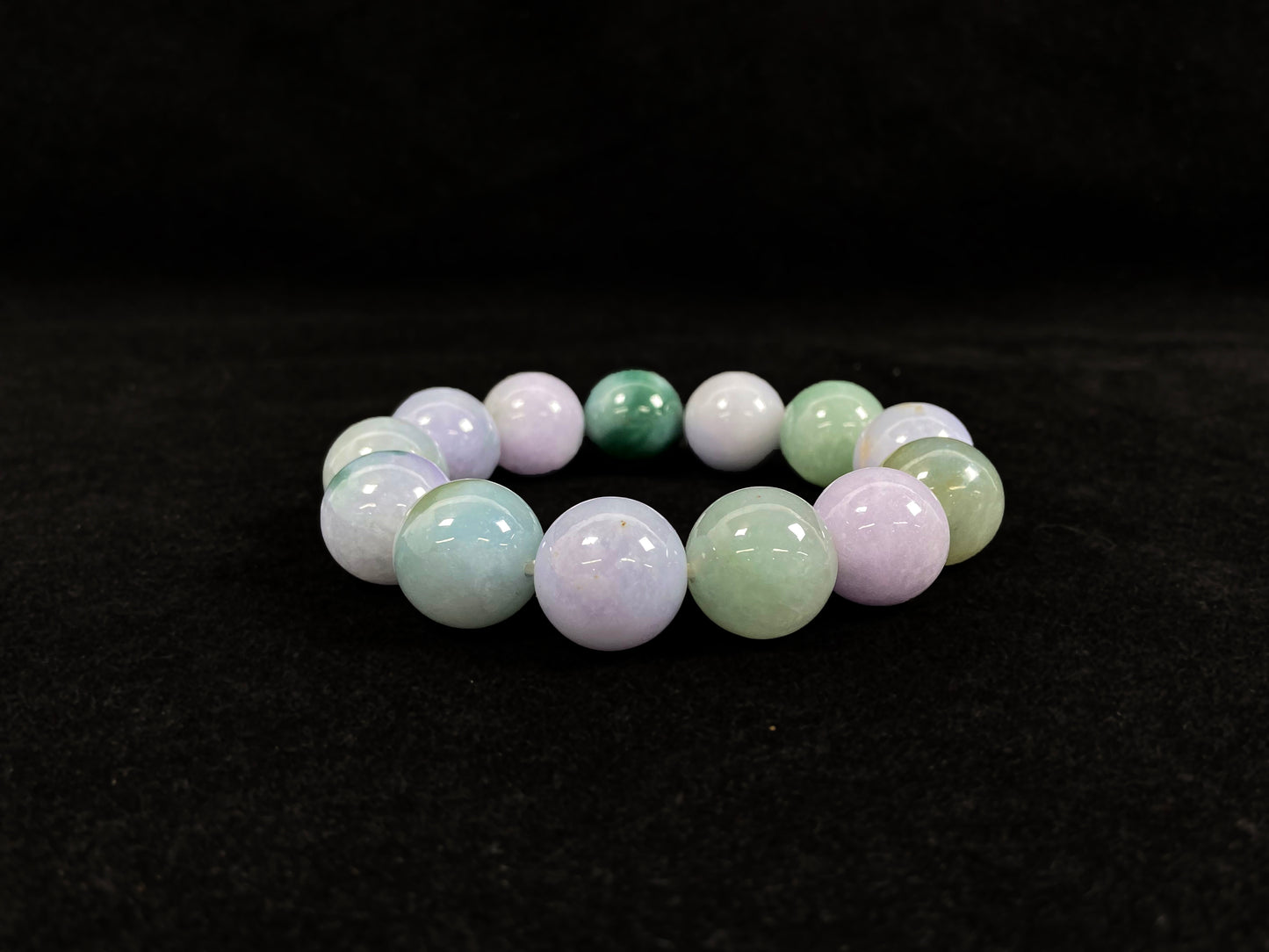 A beaded jadeite bracelet featuring purple, blue, light green, and dark green.