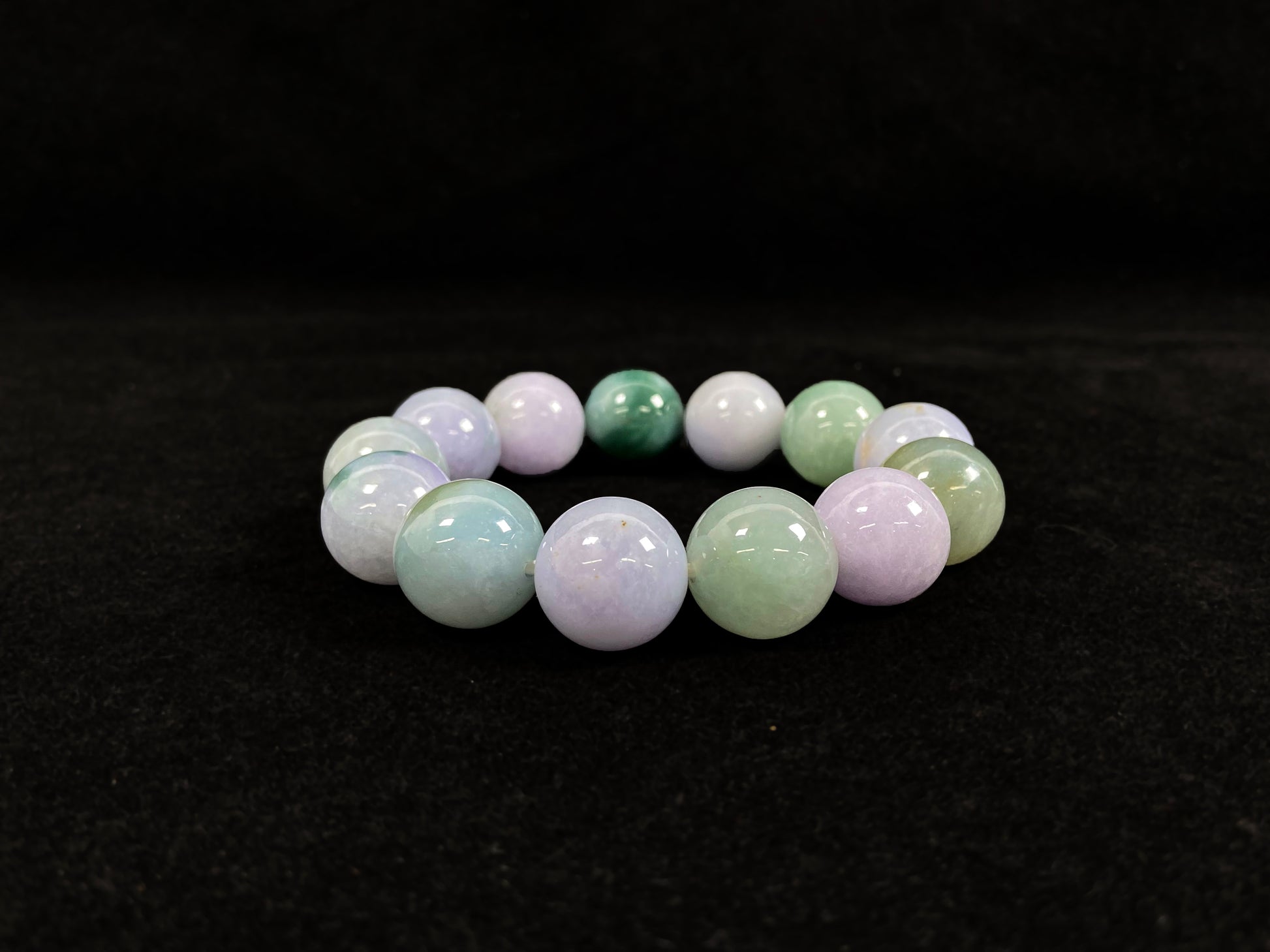 A beaded jadeite bracelet featuring purple, blue, light green, and dark green.