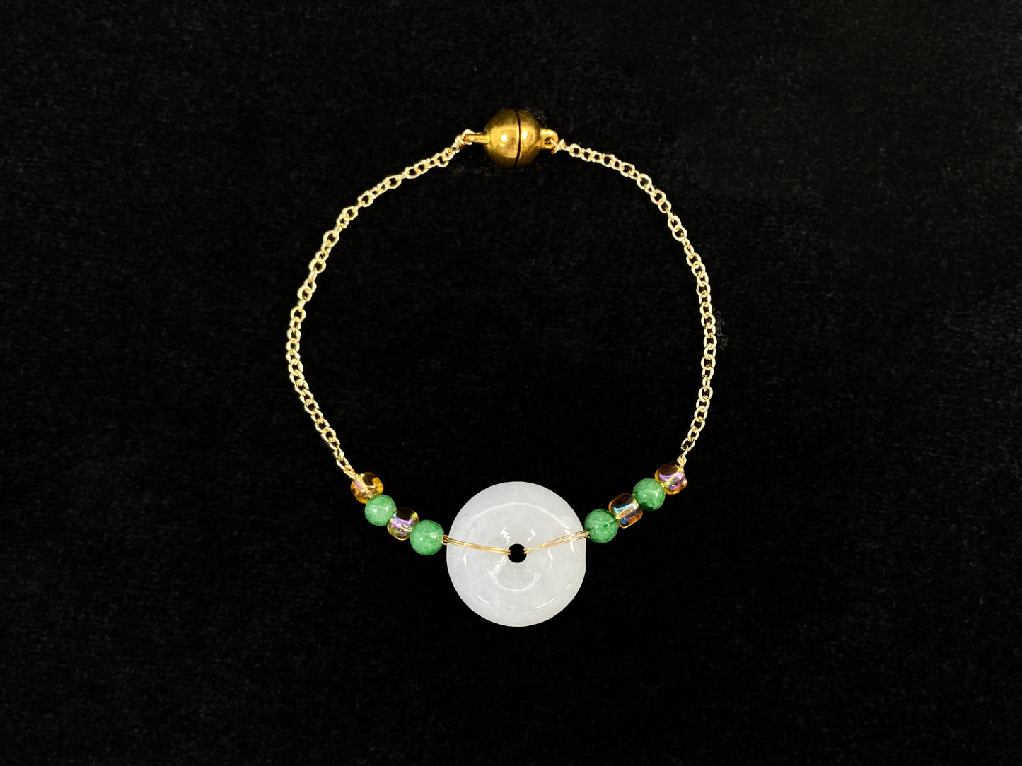 A milky white jadeite peace disc bracelet with alternating green beads and citrine crystals.