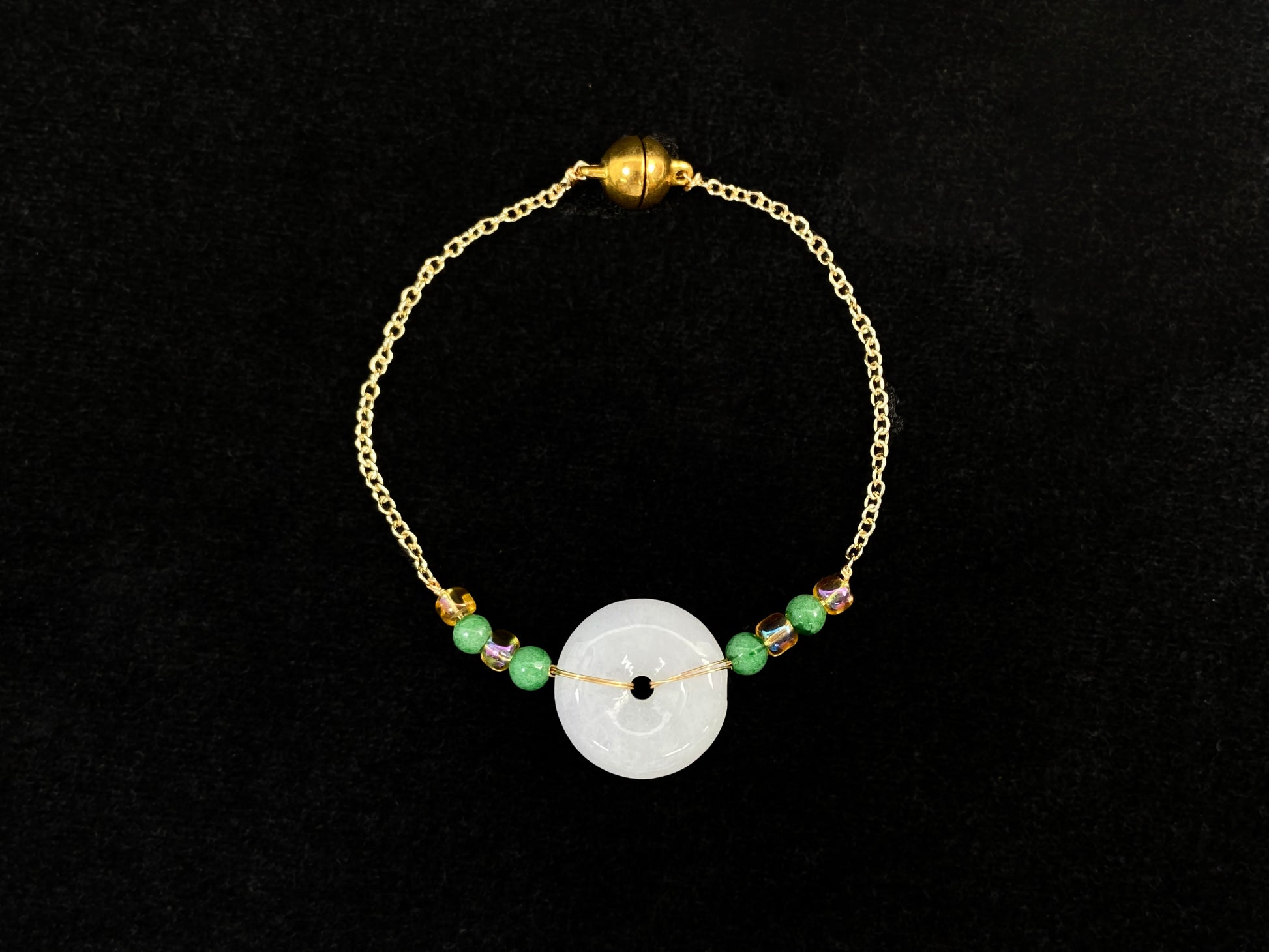 A milky white jadeite peace disc bracelet with alternating green beads and citrine crystals.
