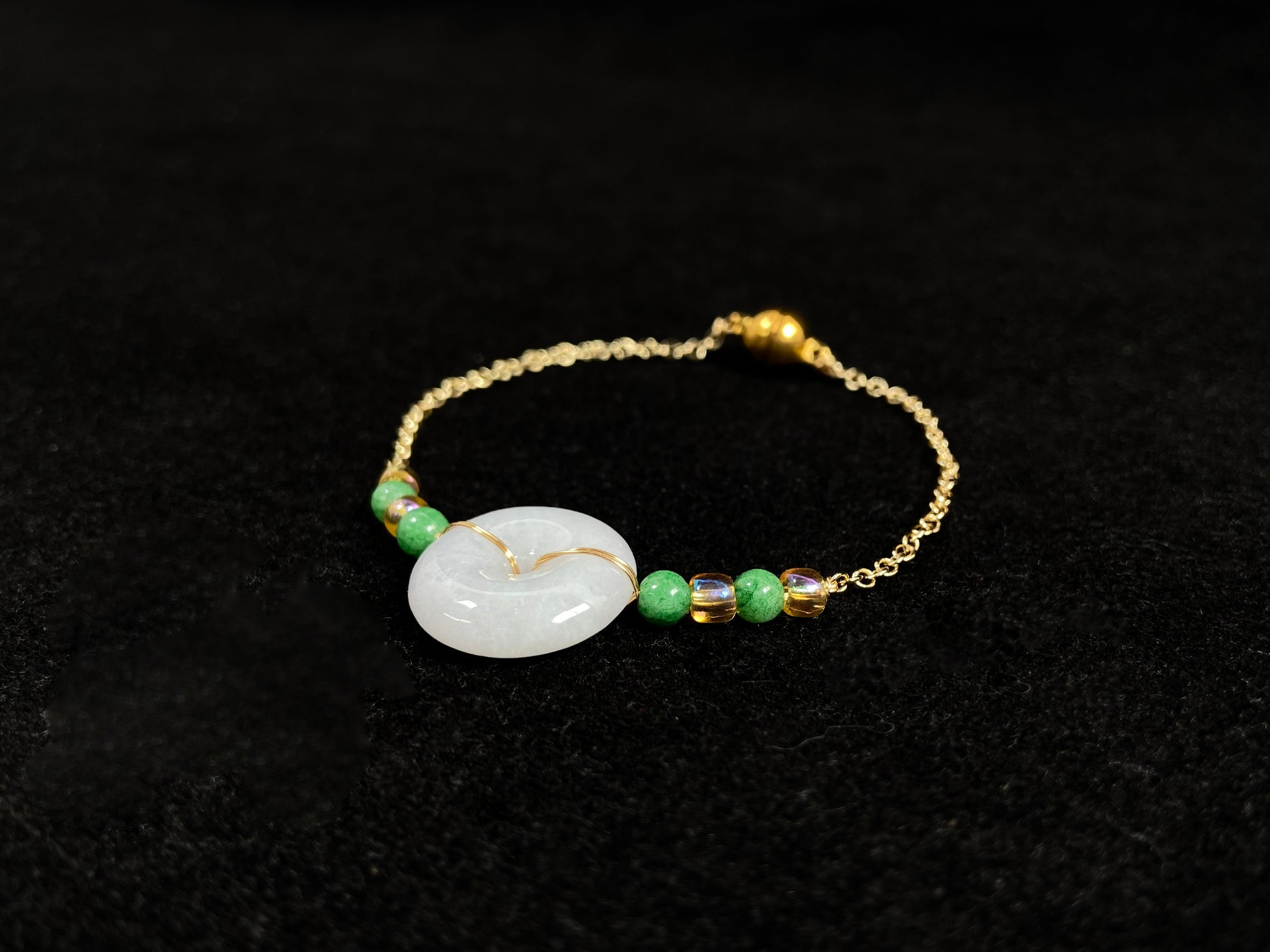 A milky white jadeite peace disc bracelet with alternating green beads and citrine crystals.