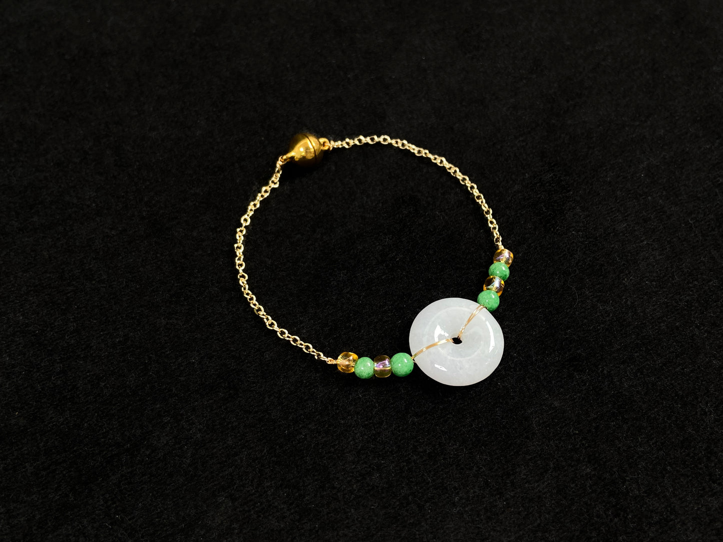 A milky white jadeite peace disc bracelet with alternating green beads and citrine crystals.