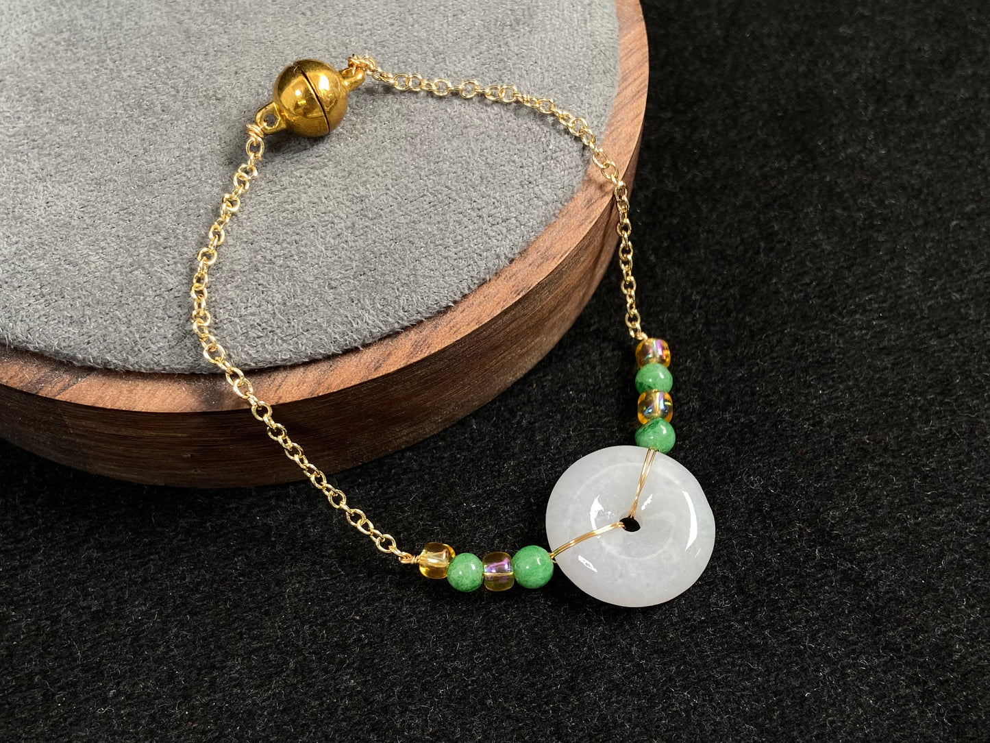 A milky white jadeite peace disc bracelet with alternating green beads and citrine crystals.