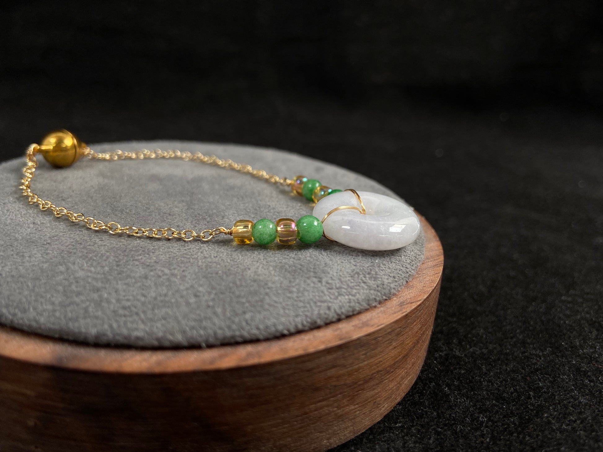 A milky white jadeite peace disc bracelet with alternating green beads and citrine crystals.