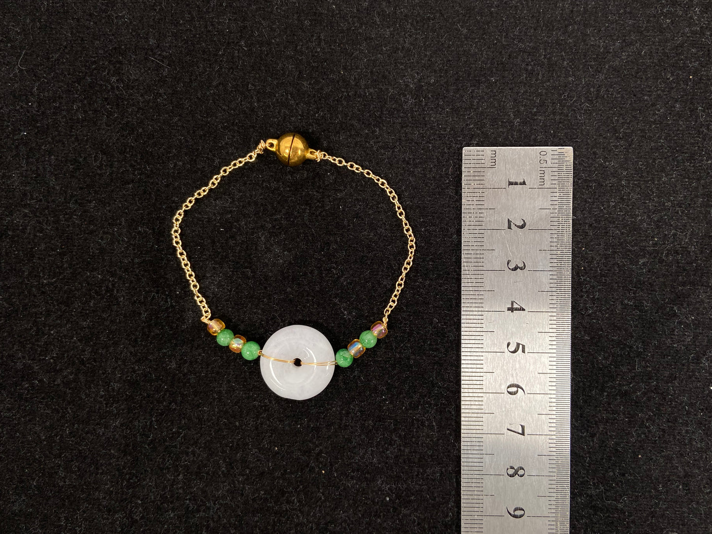 A milky white jadeite peace disc bracelet with alternating green beads and citrine crystals.