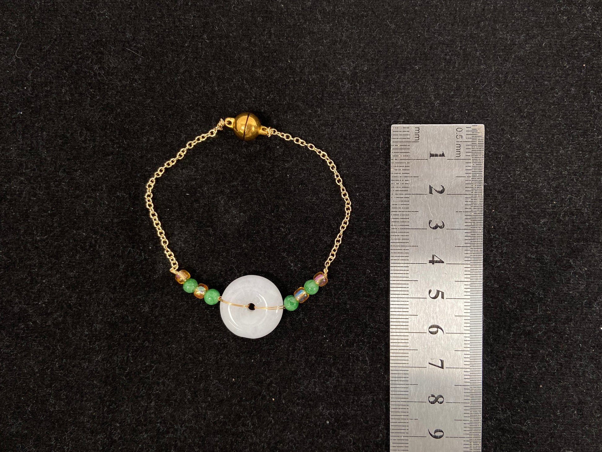 A milky white jadeite peace disc bracelet with alternating green beads and citrine crystals.