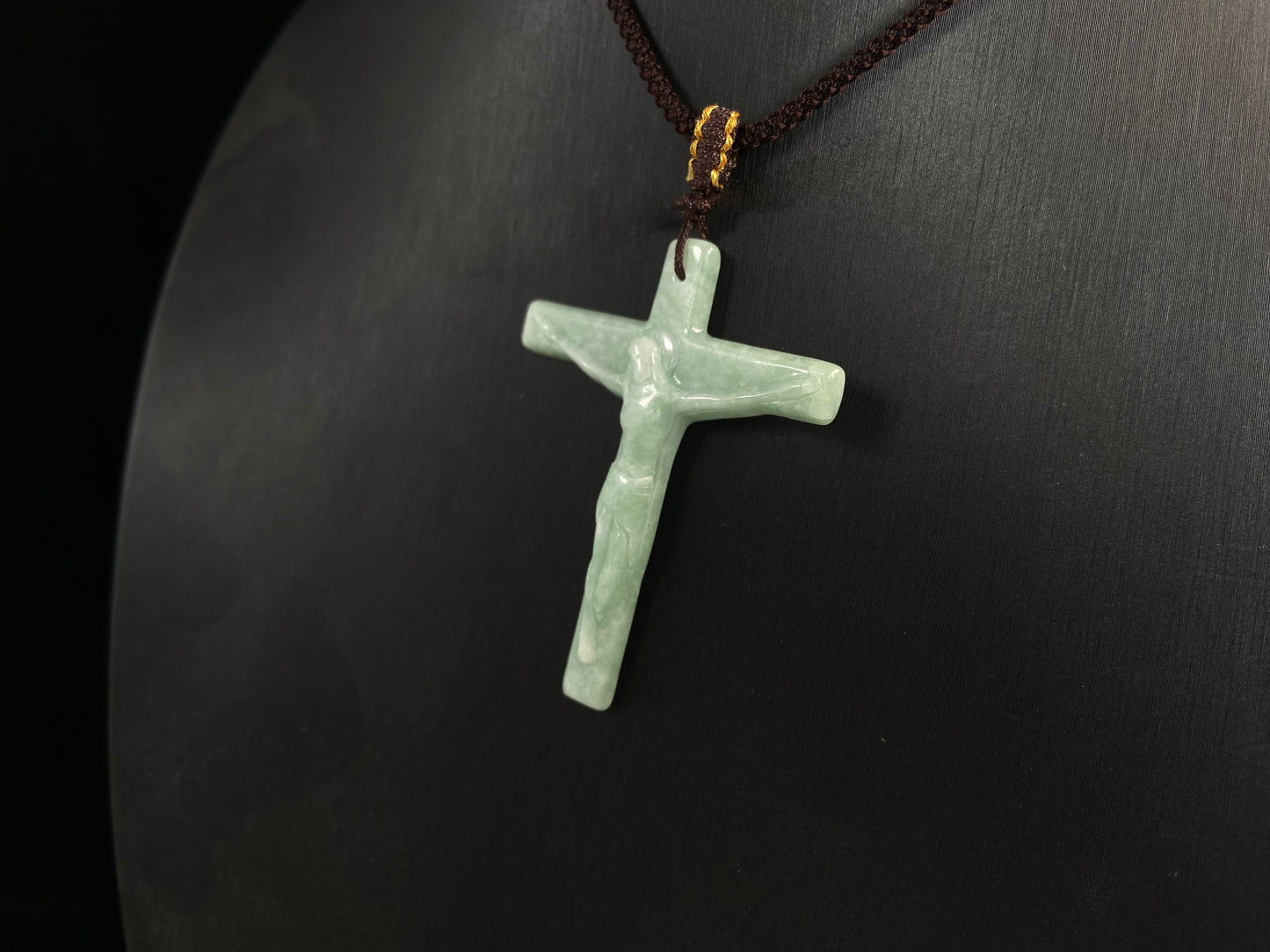 A bean green jadeite cross pendant featuring Jesus.
