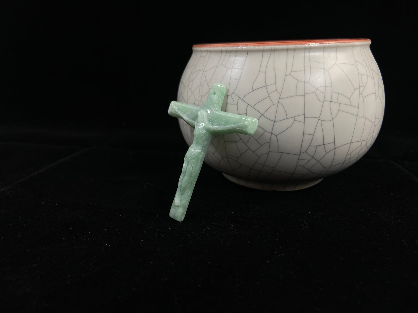 A bean green jadeite cross pendant featuring Jesus.