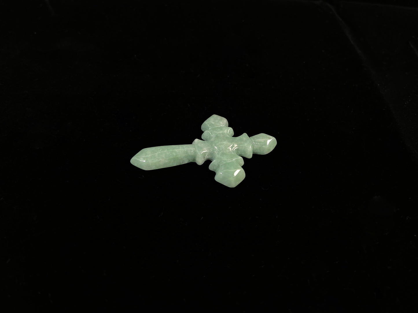 This is a pale green jadeite cross.