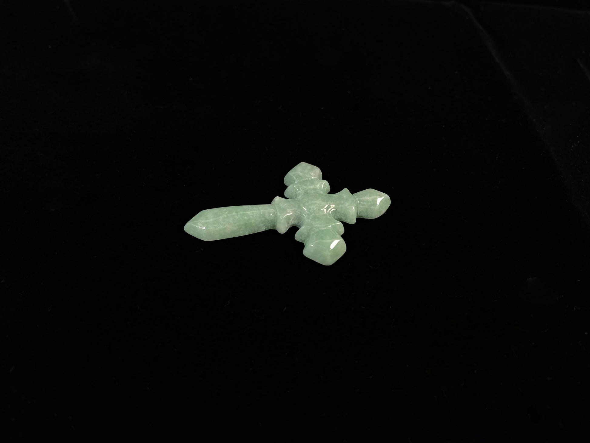This is a pale green jadeite cross.