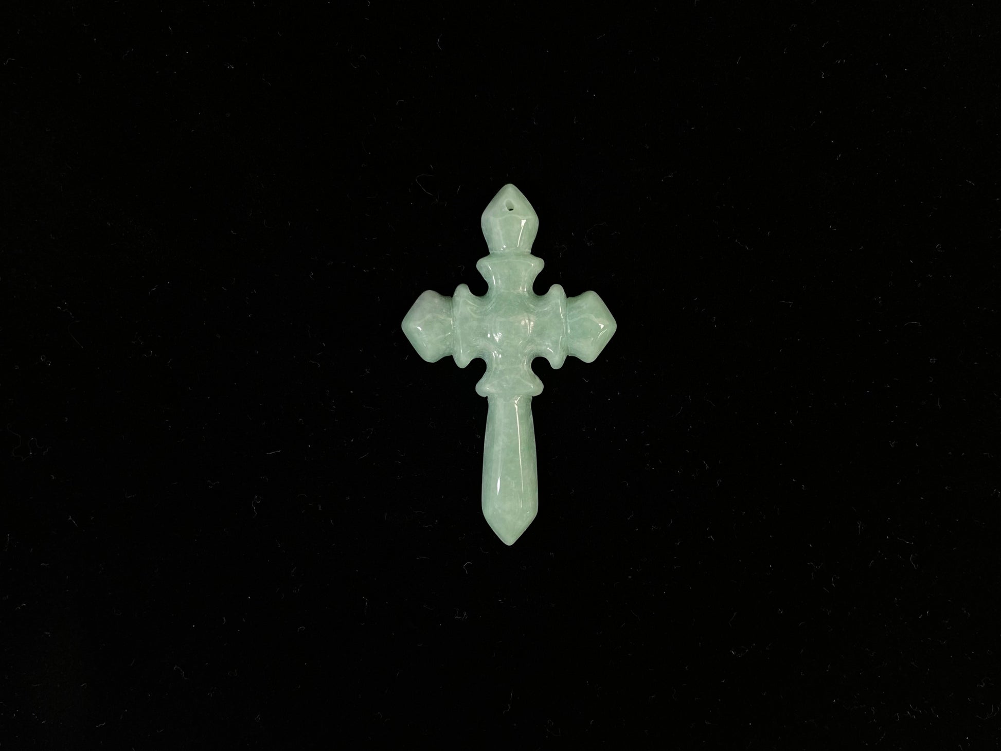 This is a pale green jadeite cross.