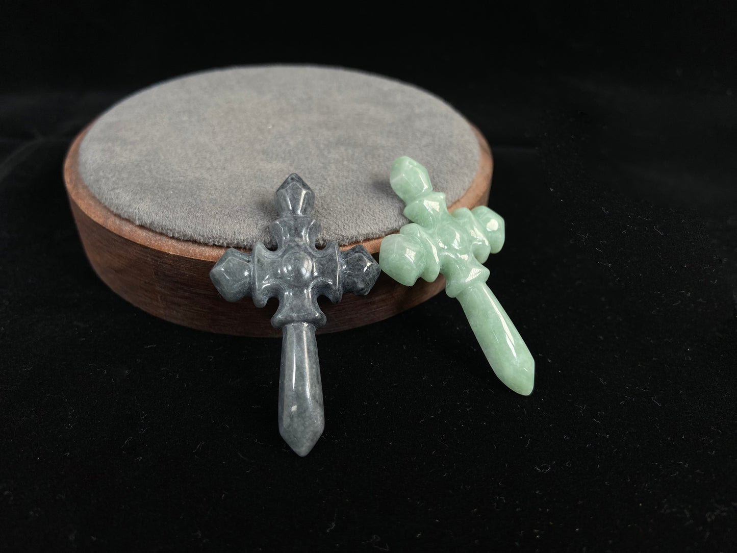 A pale green jadeite cross and a gray jadeite cross.